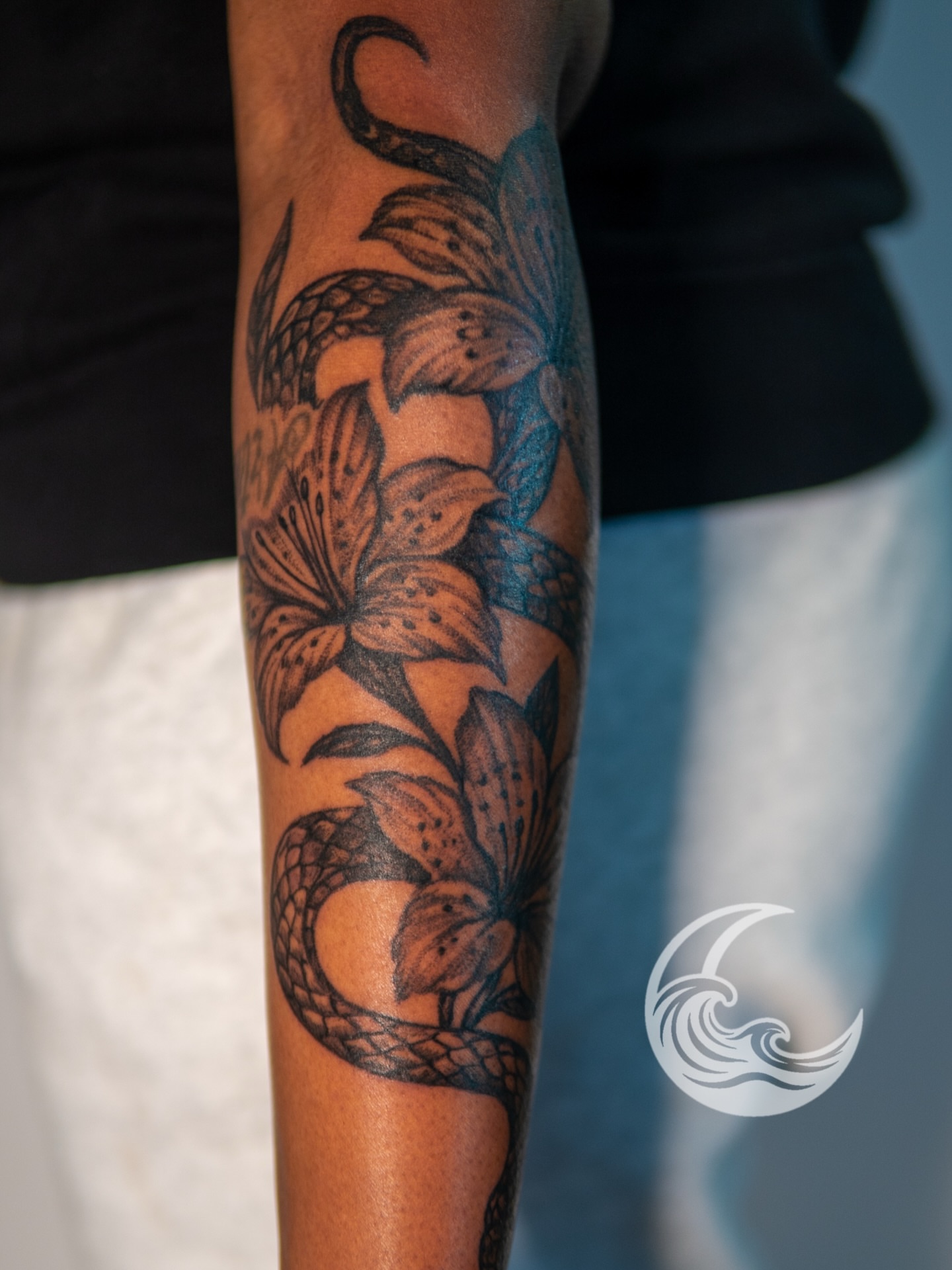 Lilies and snake black and grey tattoo on the forearm by Justin custard Tattoo💉Artist 🎨Painter