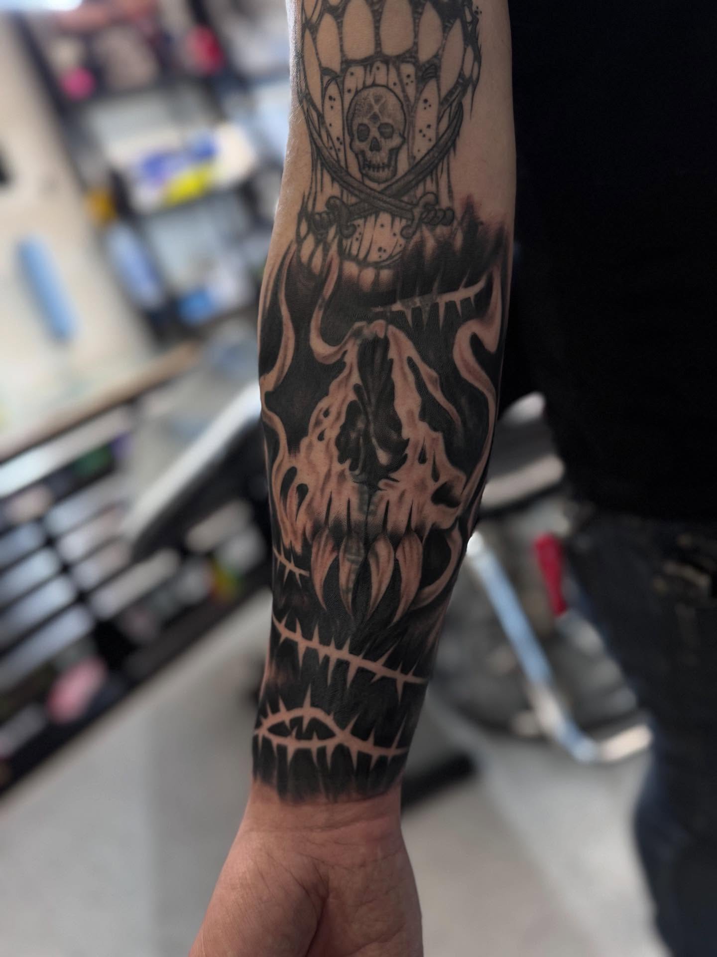 Flaming skull dark realism tattoo on the forearm by Jacob - Tattoo Artist