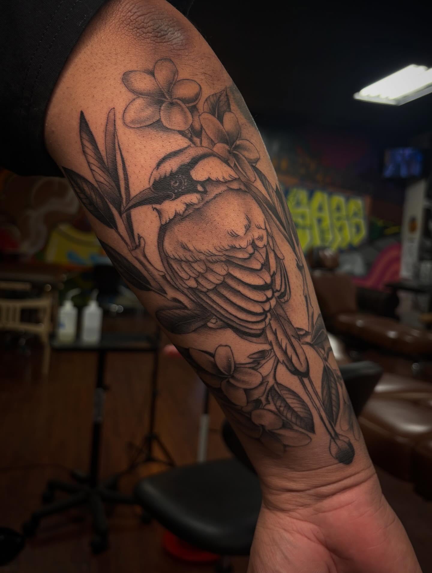 Bird and flowers black and grey tattoo on the forearm by Alexandria