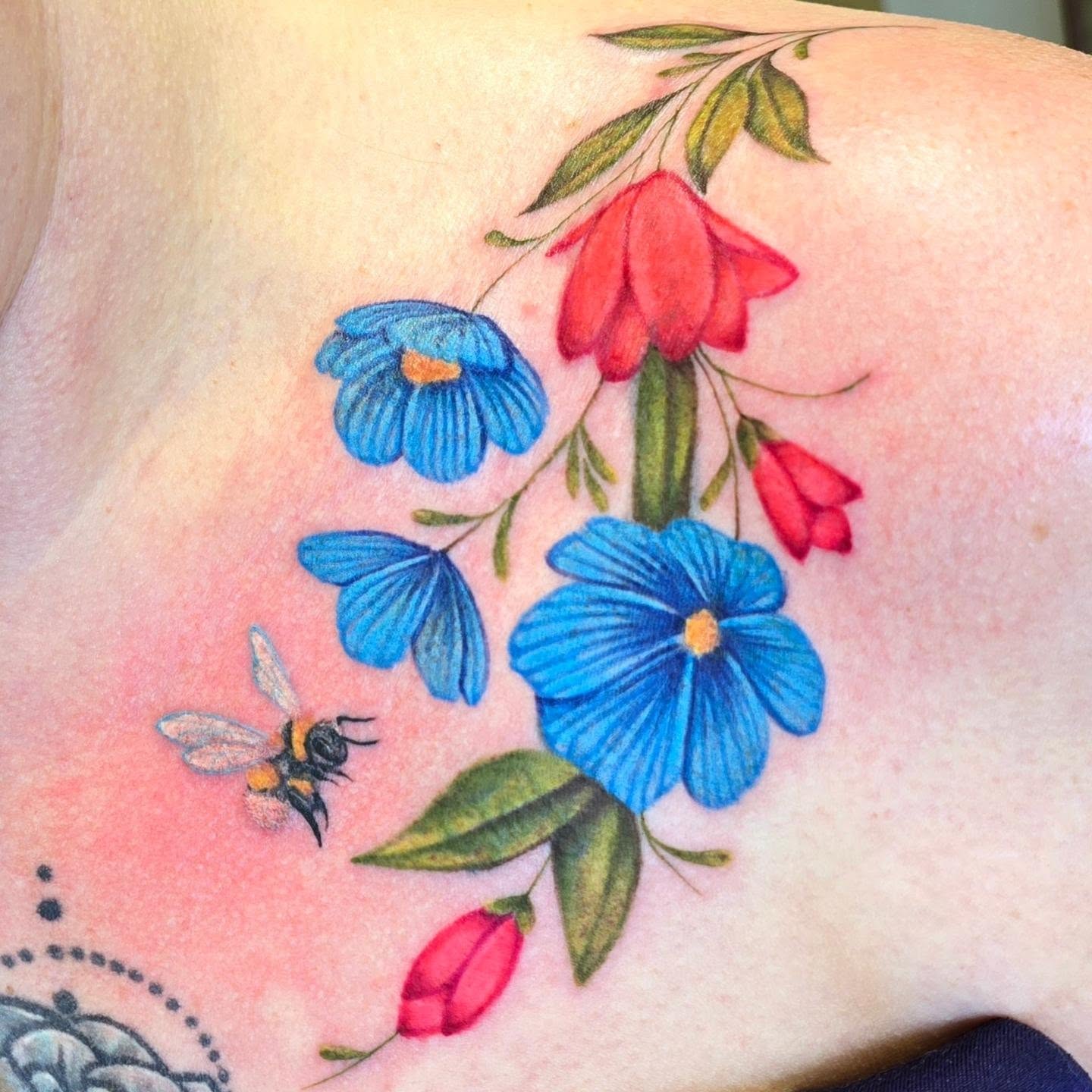 Flowers and bee realism tattoo on the shoulder by Emily Louise Tattoos