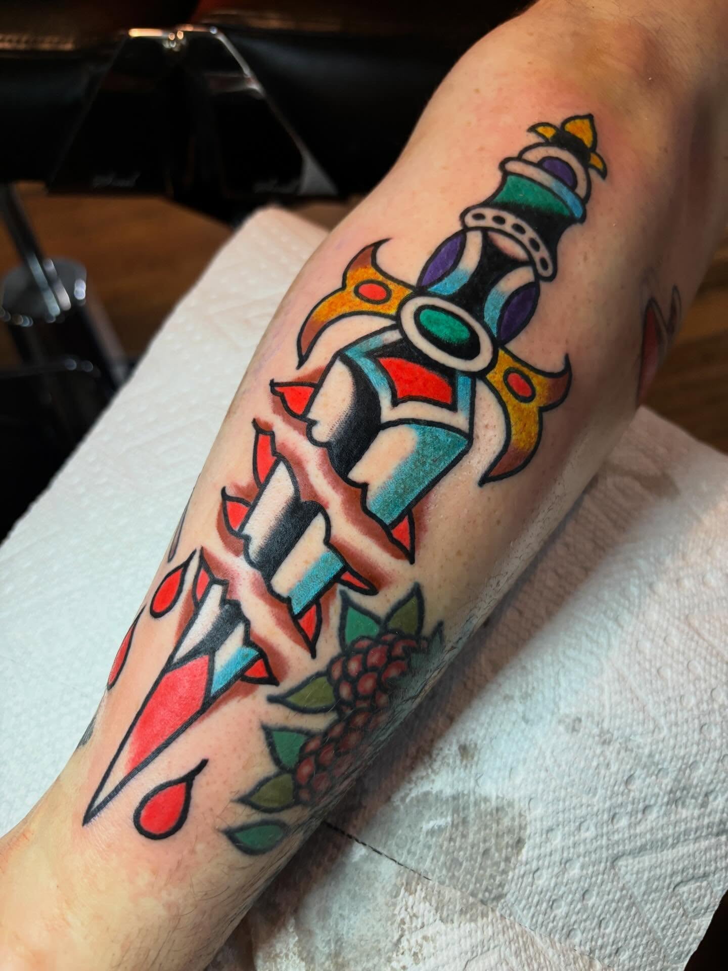 Sword and grapes American traditional tattoo on the forearm by Mitch Ashpaugh