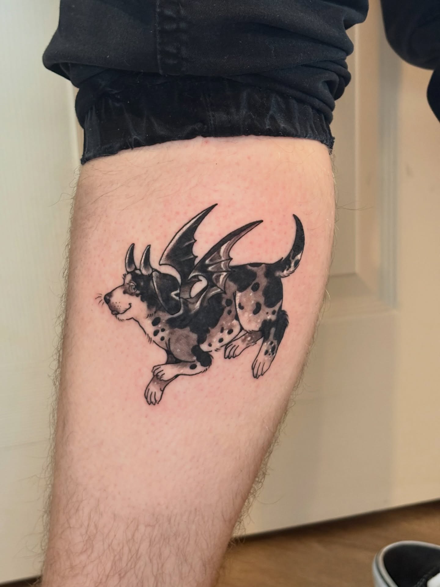 Dog with bat wings dotwork tattoo on the thigh by Callum