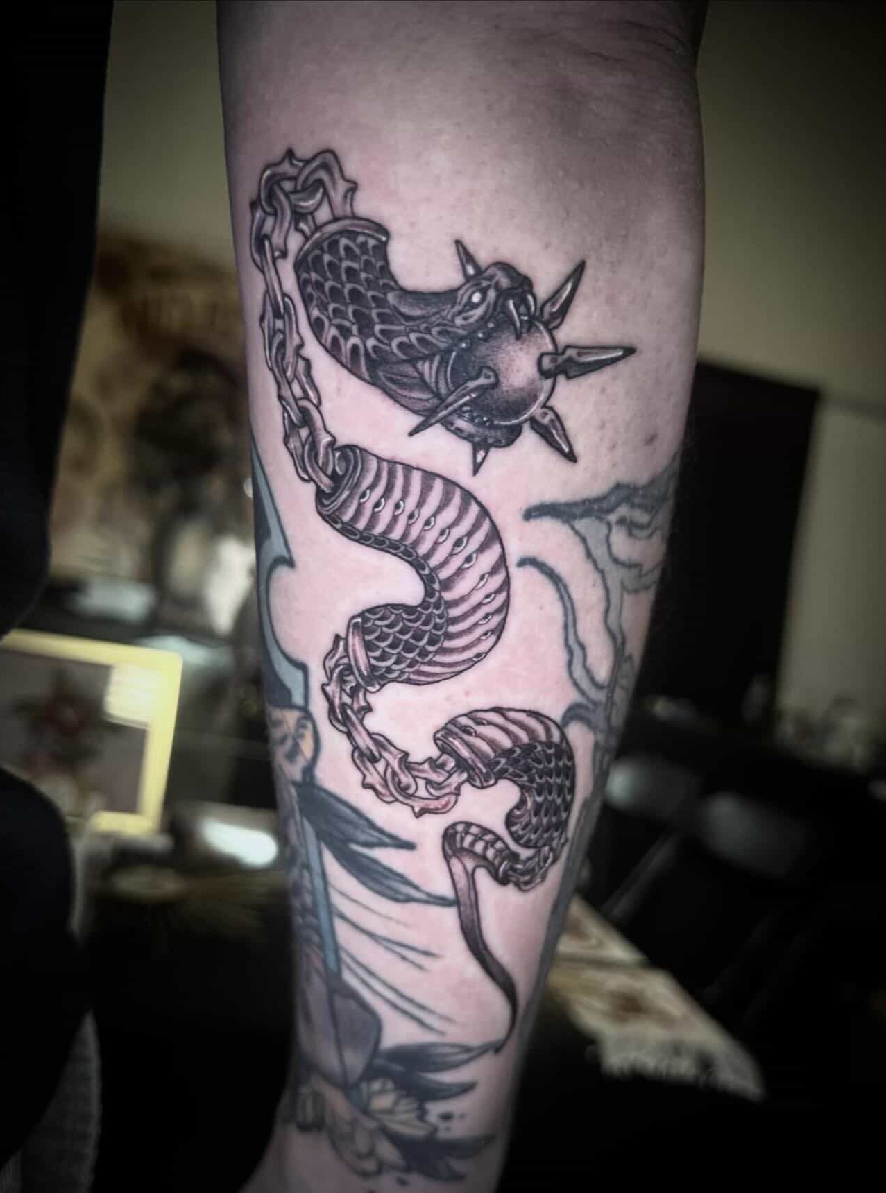Serpent black and grey tattoo on the forearm by Sierra