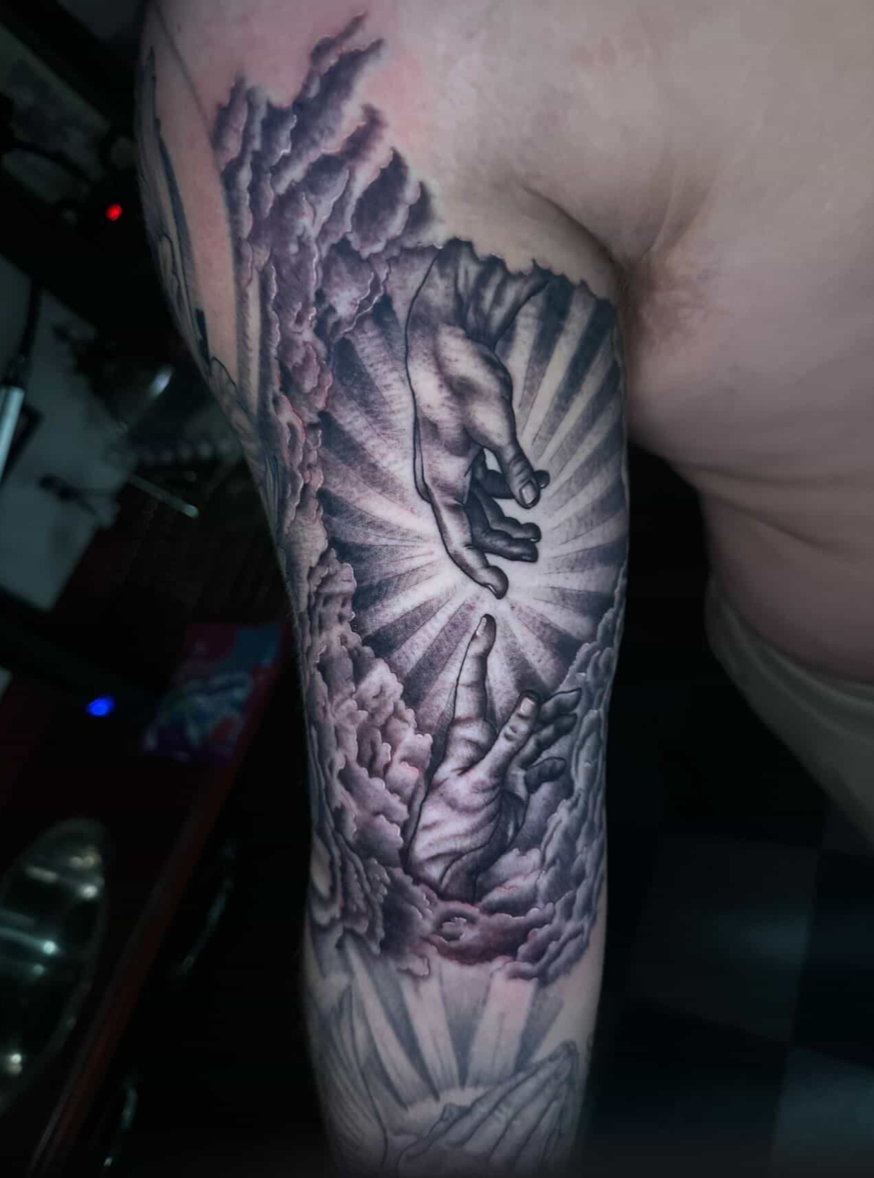 Hands reaching through clouds realism tattoo on the forearm by Sierra