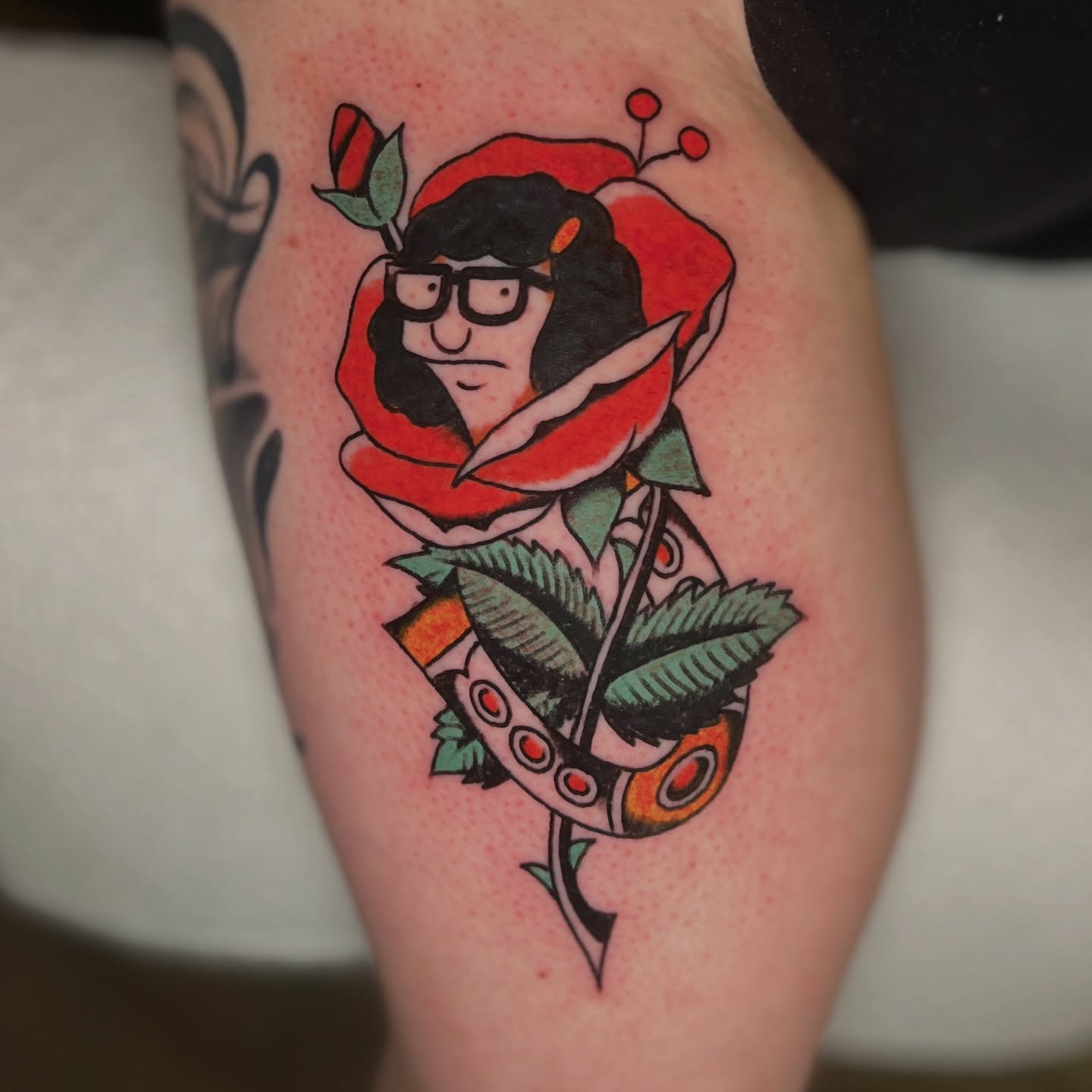 Rose with face American traditional tattoo on the thigh by Andrew Storm