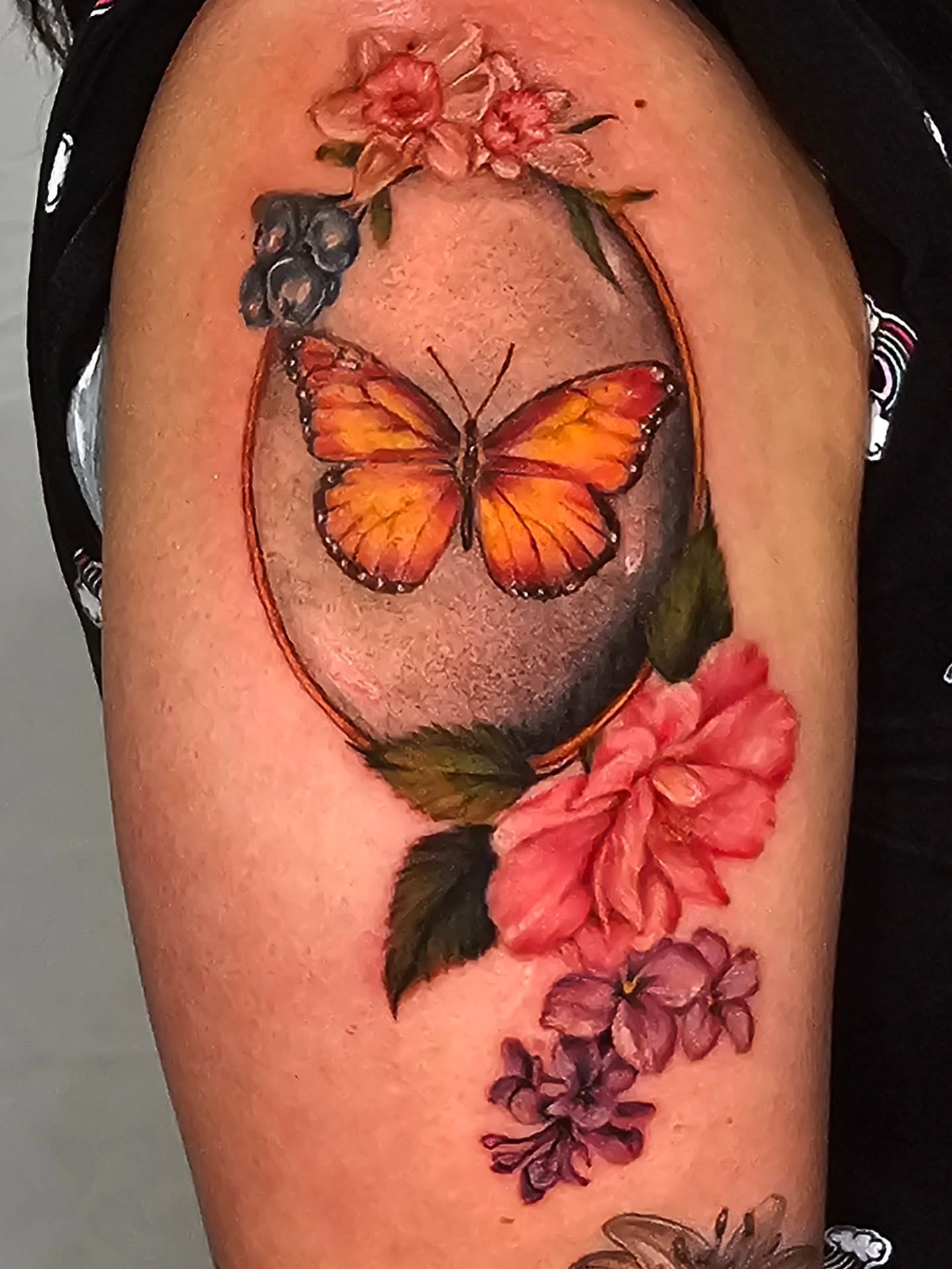 Butterfly and flowers realism tattoo on the upper arm by Madelynne