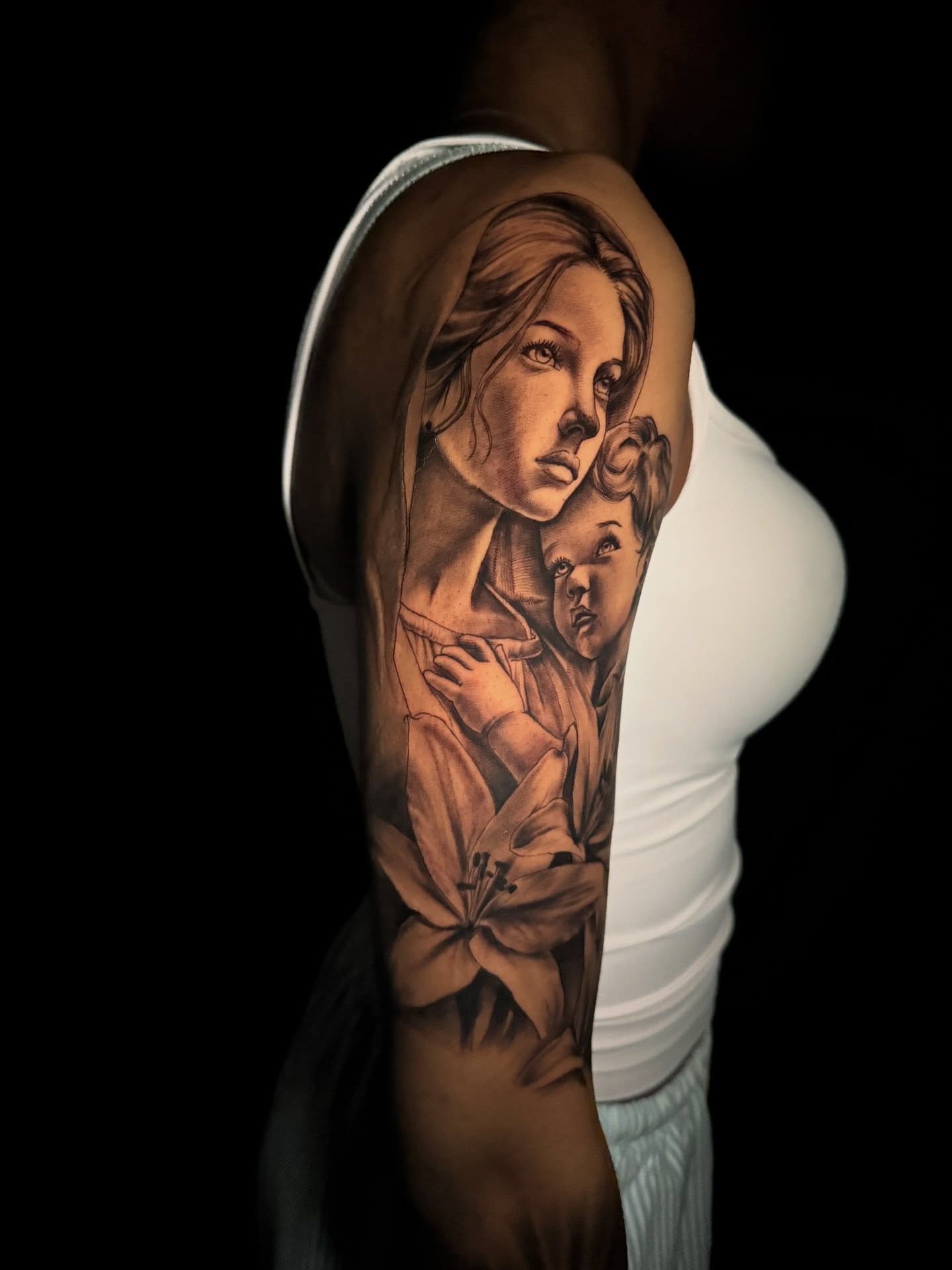Religious figure with child realism tattoo on the upper arm by Atl Tattoo Artist✍🏾👨🏾‍🎨