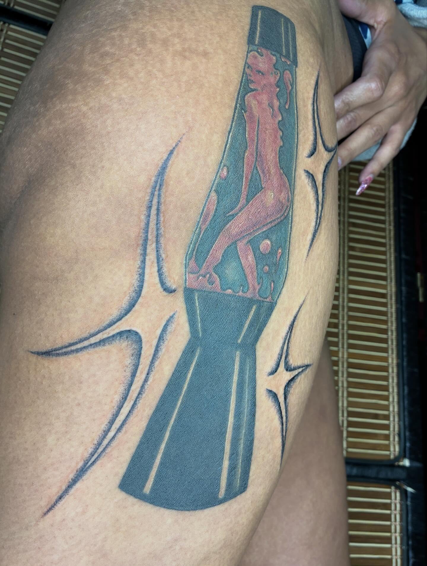 Naked woman in bottle black and grey tattoo on the thigh by Steven Sessler, San Francisco, California