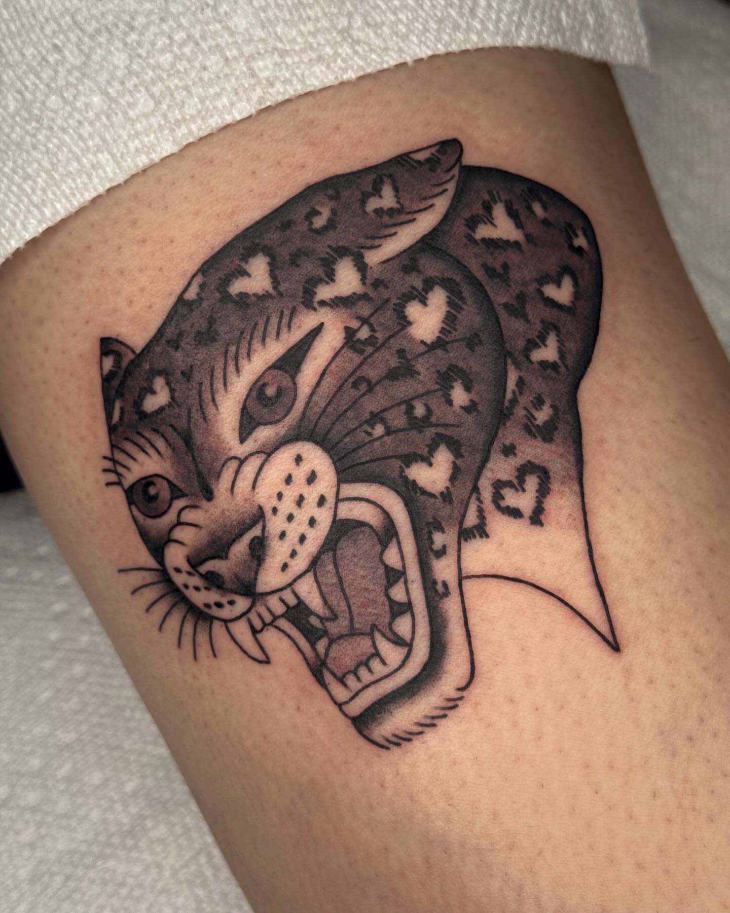Leopard black and grey tattoo on the thigh by Bridgette Carberry