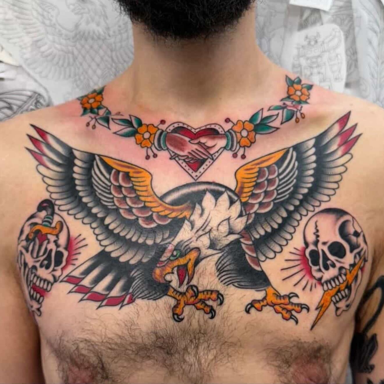 Eagle and skulls American traditional tattoo on the chest by Chris de Armas