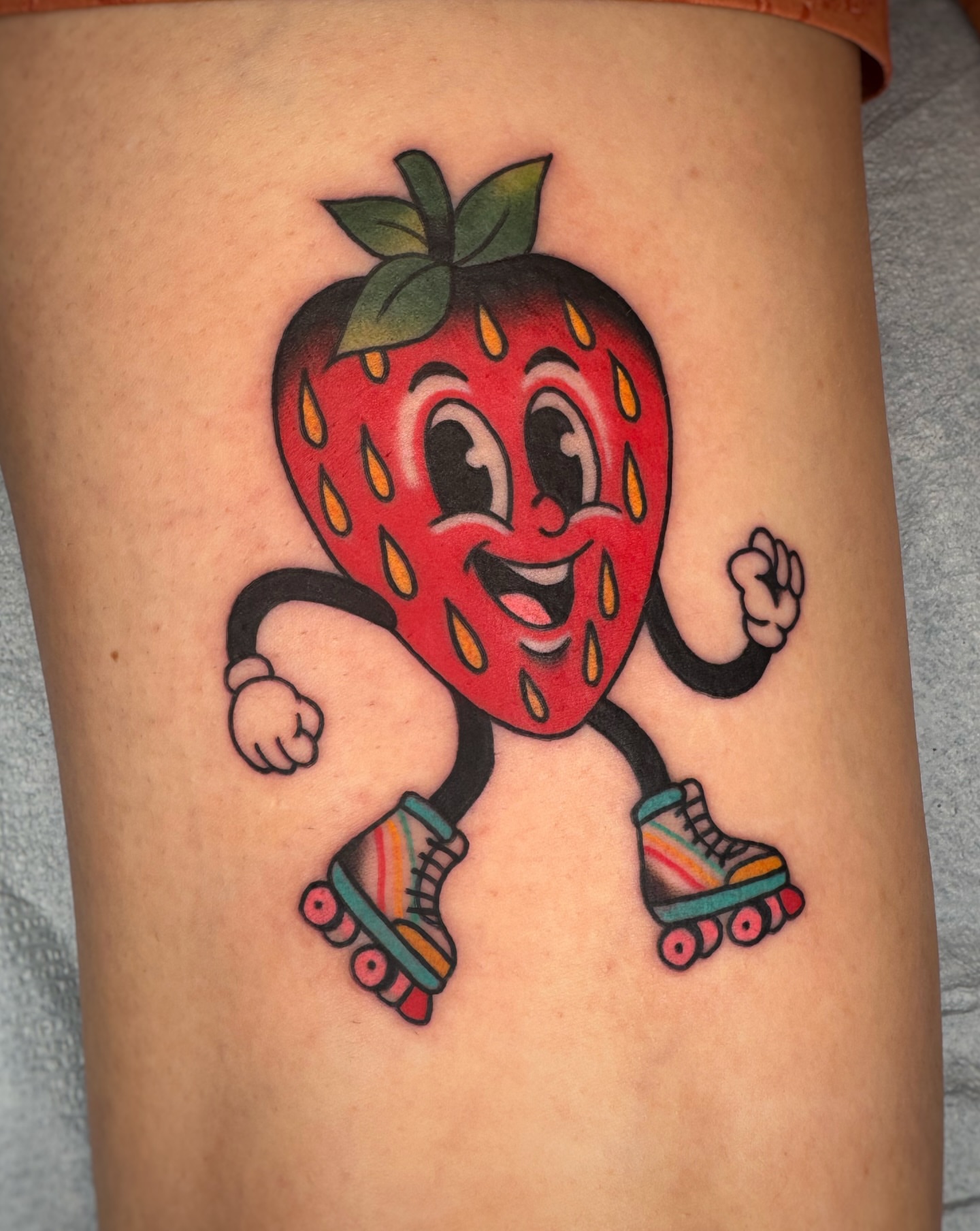 Strawberry roller skater American traditional tattoo on the thigh by Cori James Tattoo Artist