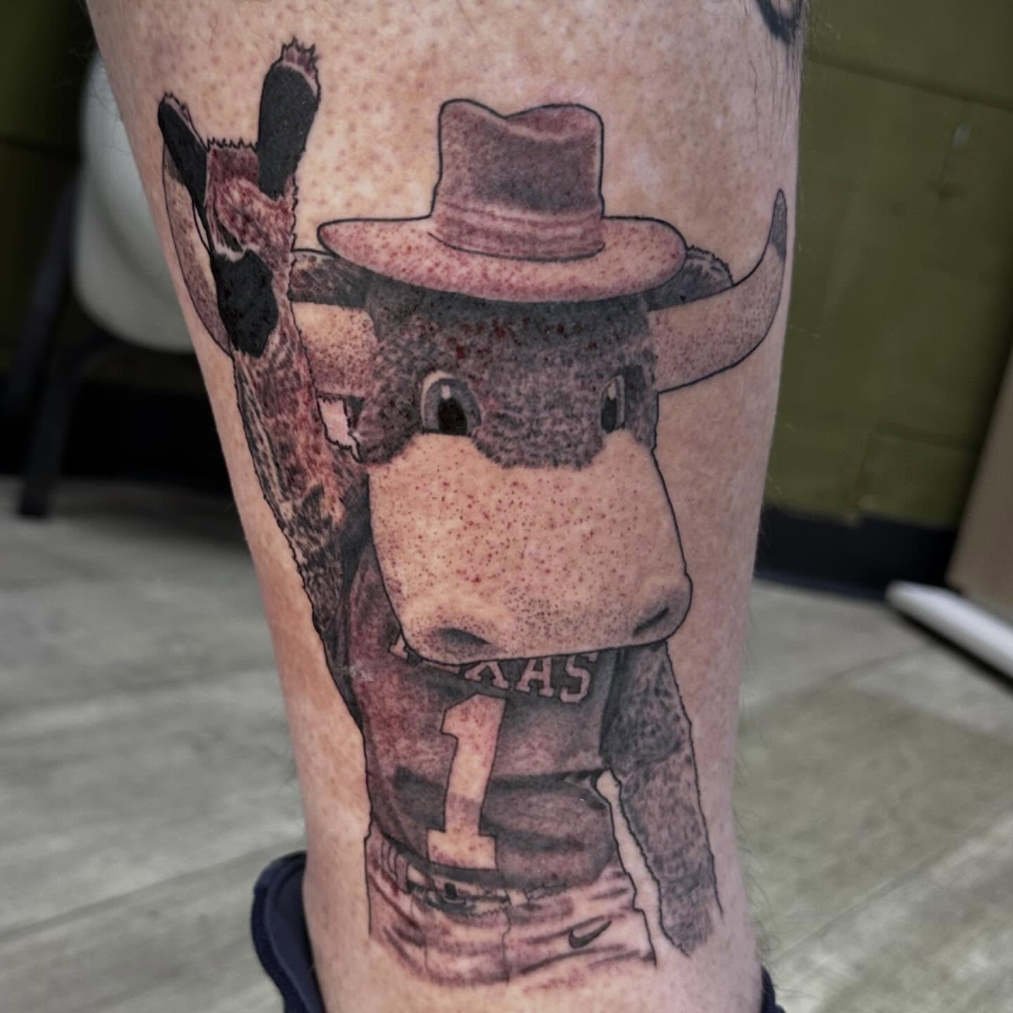 Cow wearing cowboy hat black and grey tattoo on the forearm by Dustin Clark, Dayton, Ohio