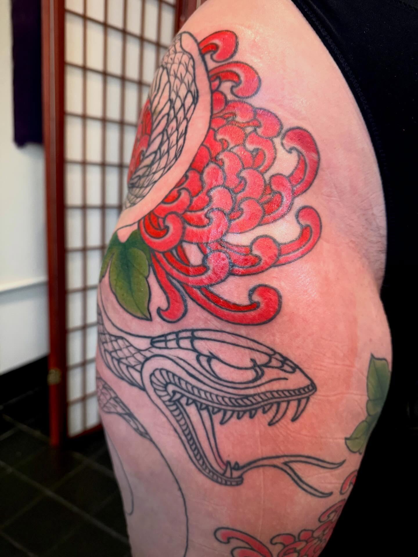 Snake and peony American traditional tattoo on the shoulder by Candi Kinyōbi