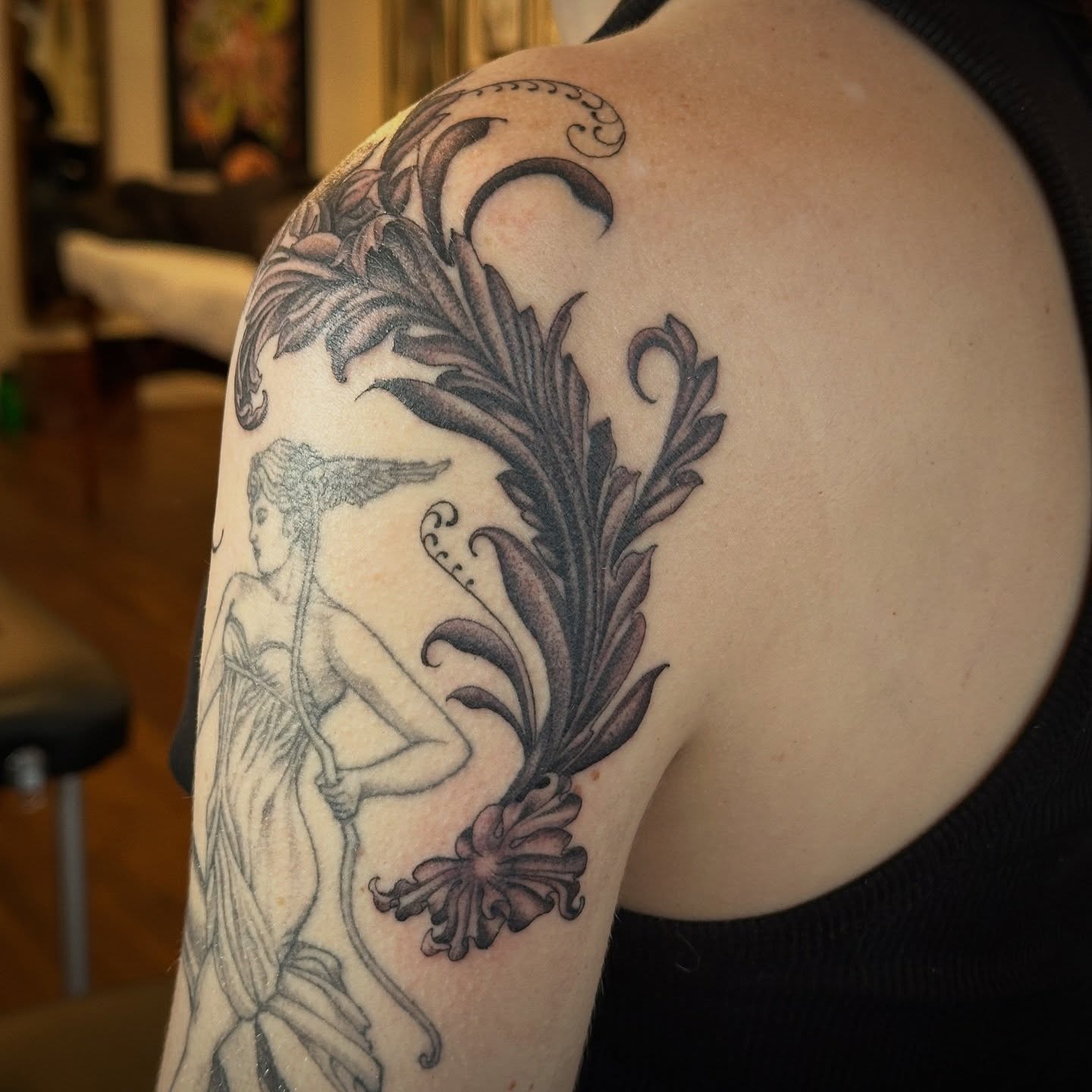 Mythical figure with floral elements ornamental tattoo on the shoulder by Bree Lin