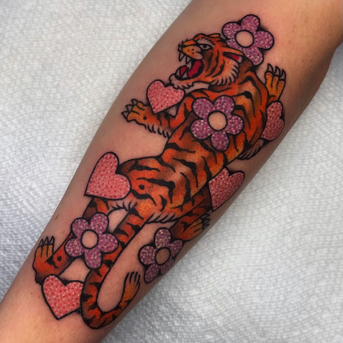 Tiger with hearts and flowers American traditional tattoo on the forearm by Larry Love