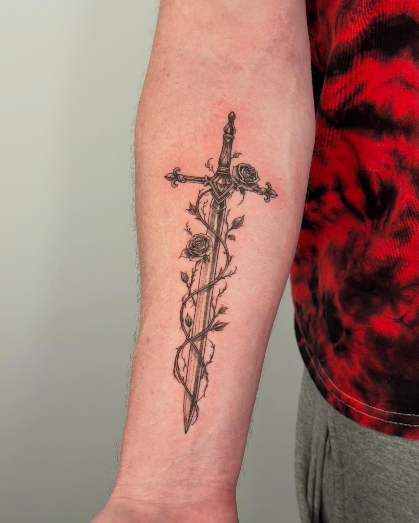 Sword and roses black and grey tattoo on the forearm by Felipe Pacifico