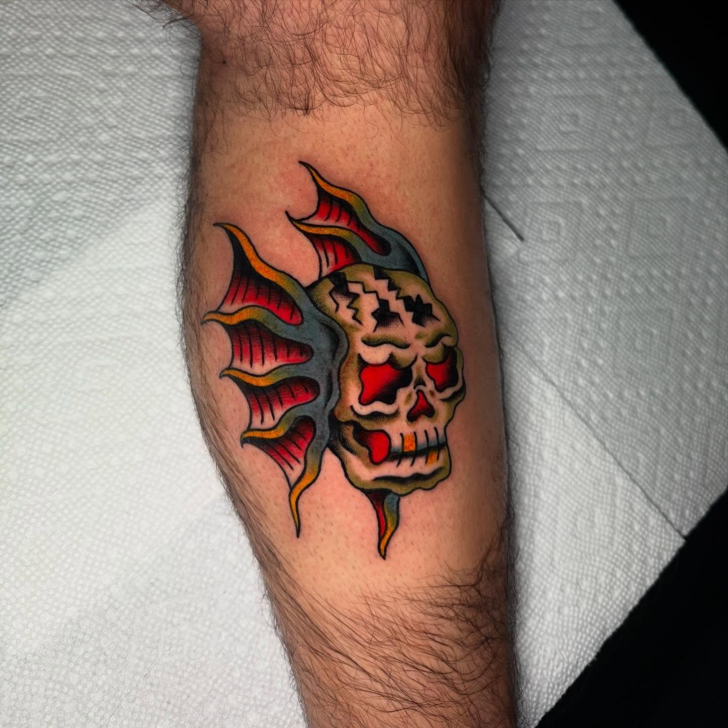Skull with flames American traditional tattoo on the forearm by Mallory Brown