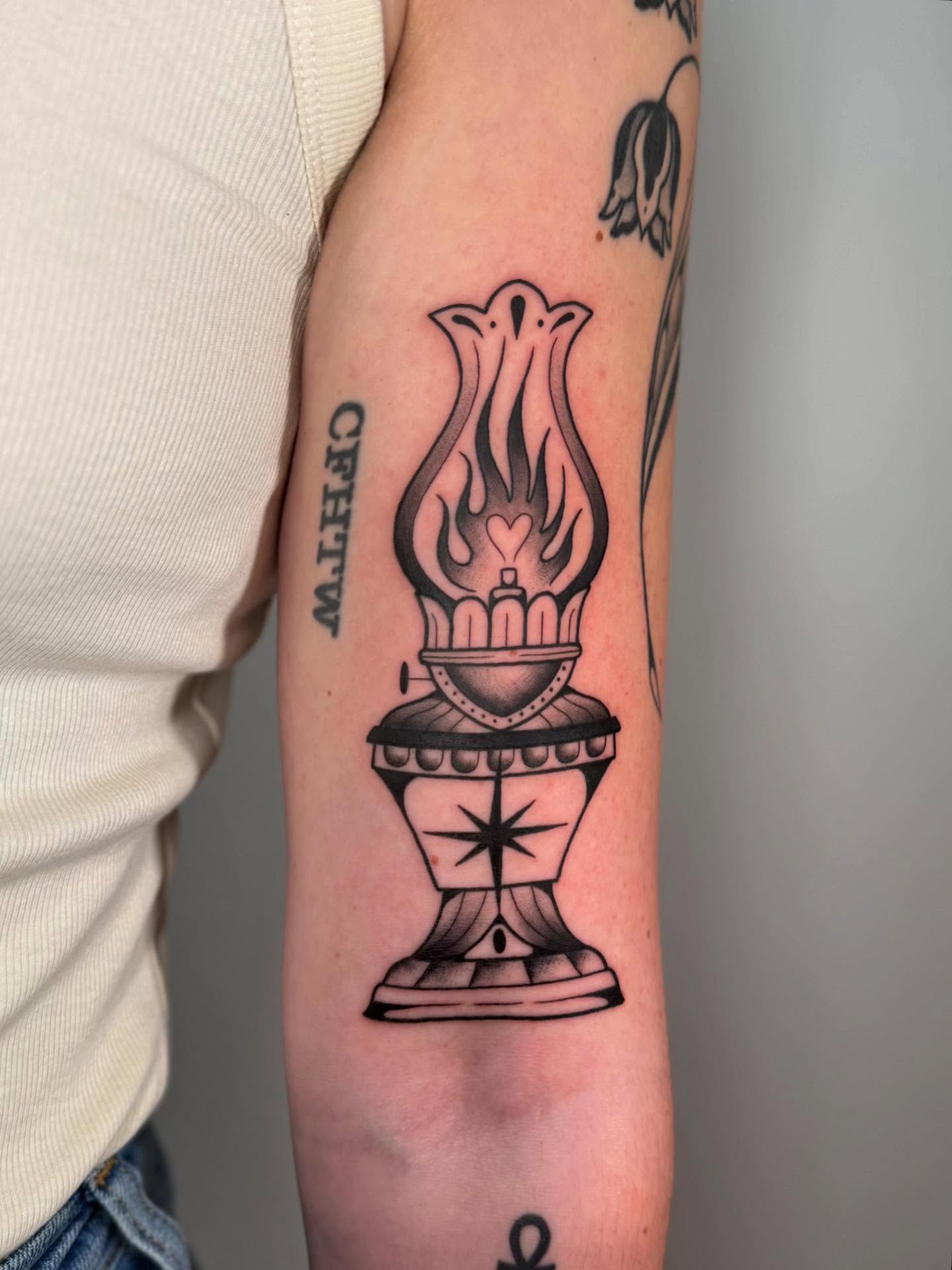 Oil lamp black and grey tattoo on the forearm by Kail