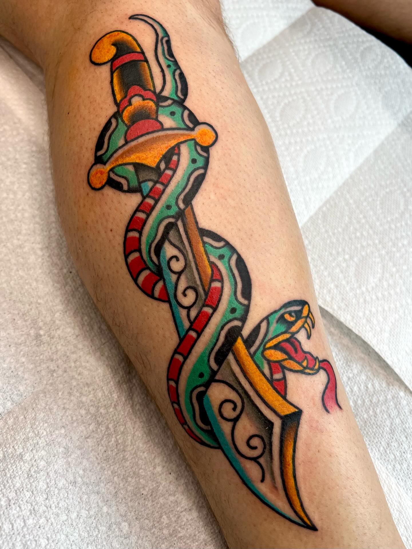 Snake and dagger American traditional tattoo on the forearm by Brandon McDaniel Iowa Tattoo Artist
