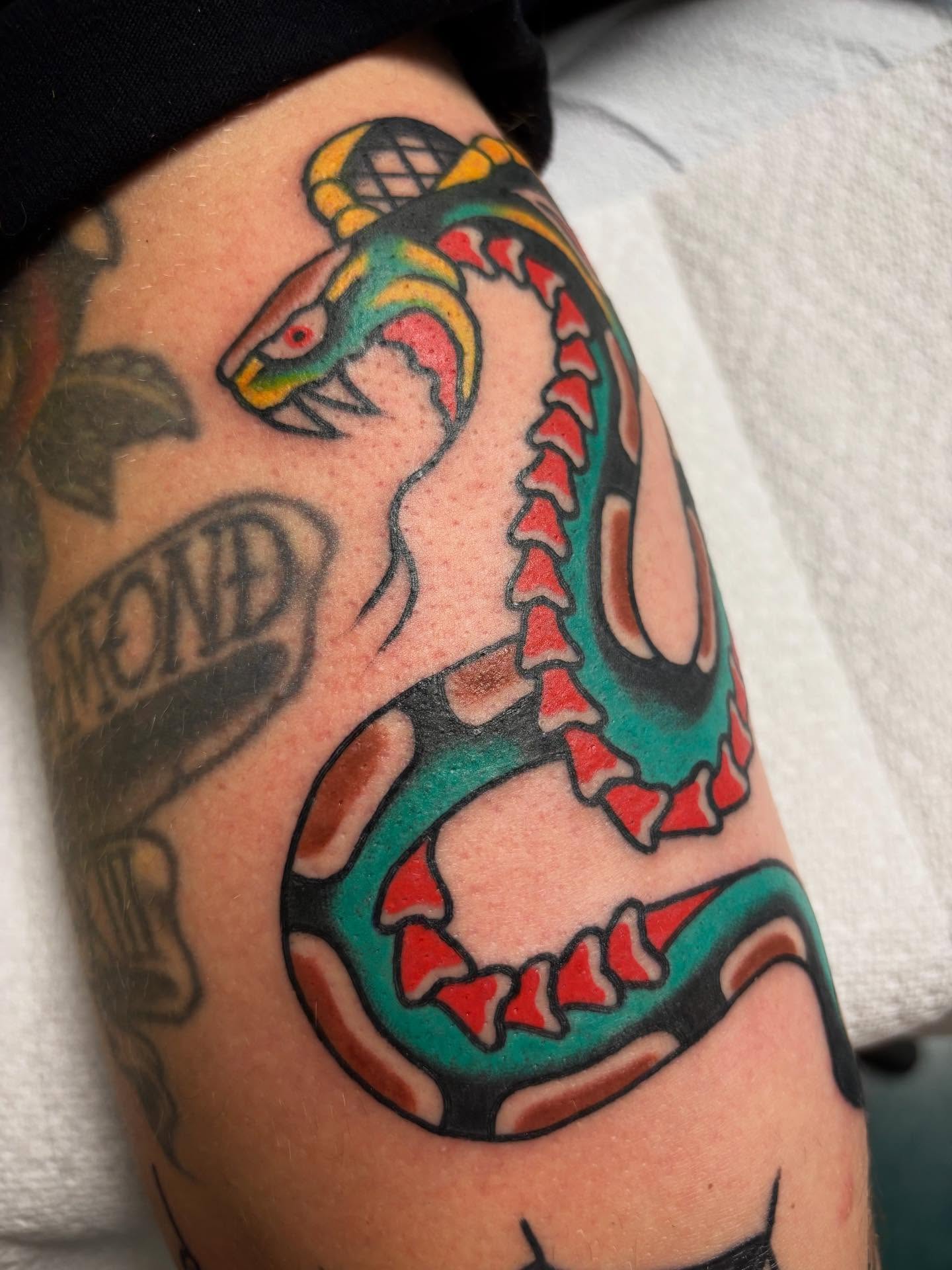 Serpent American traditional tattoo on the upper arm by 🌹