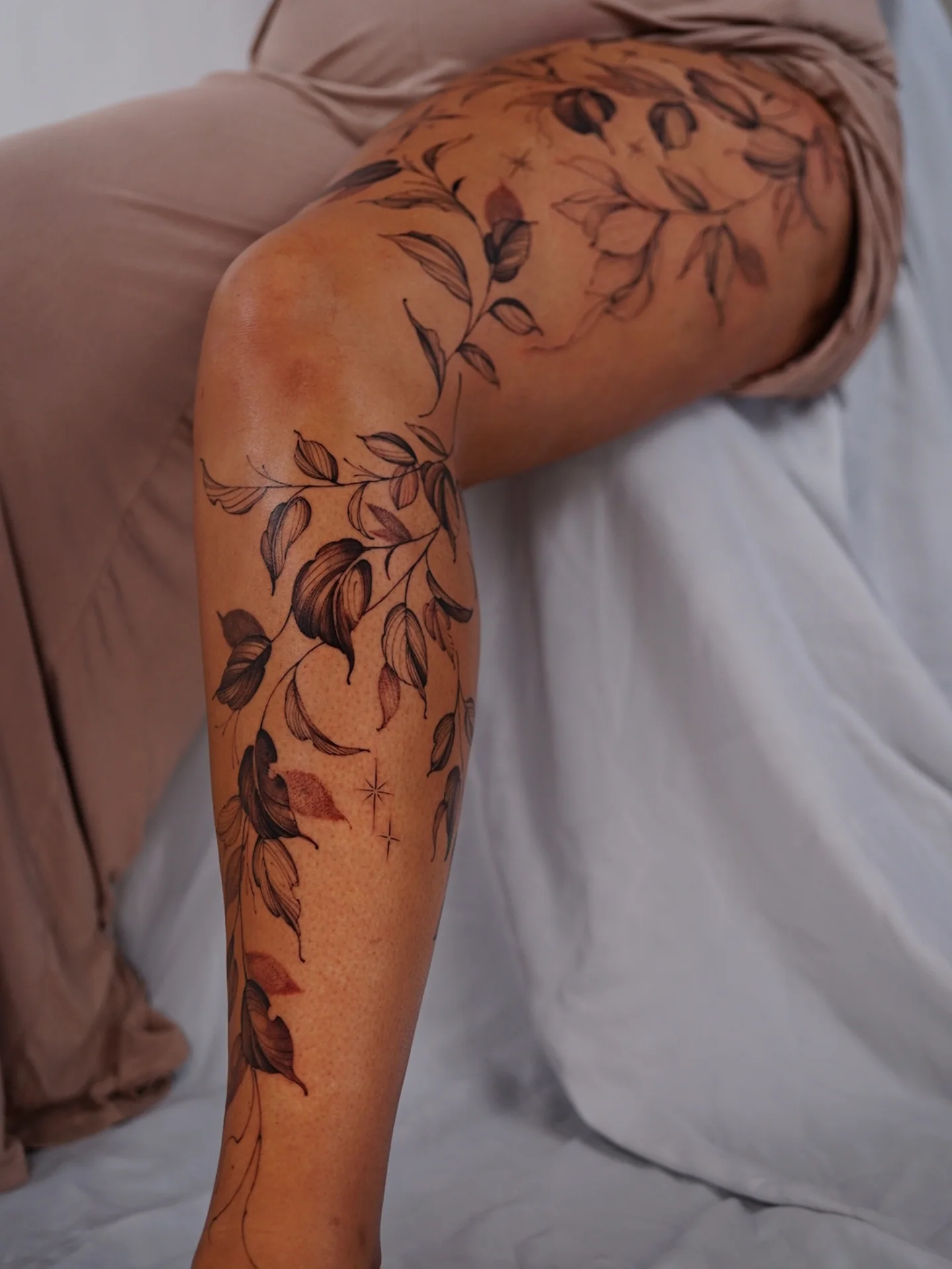 Leafy branches black and grey tattoo on the upper arm by Vii