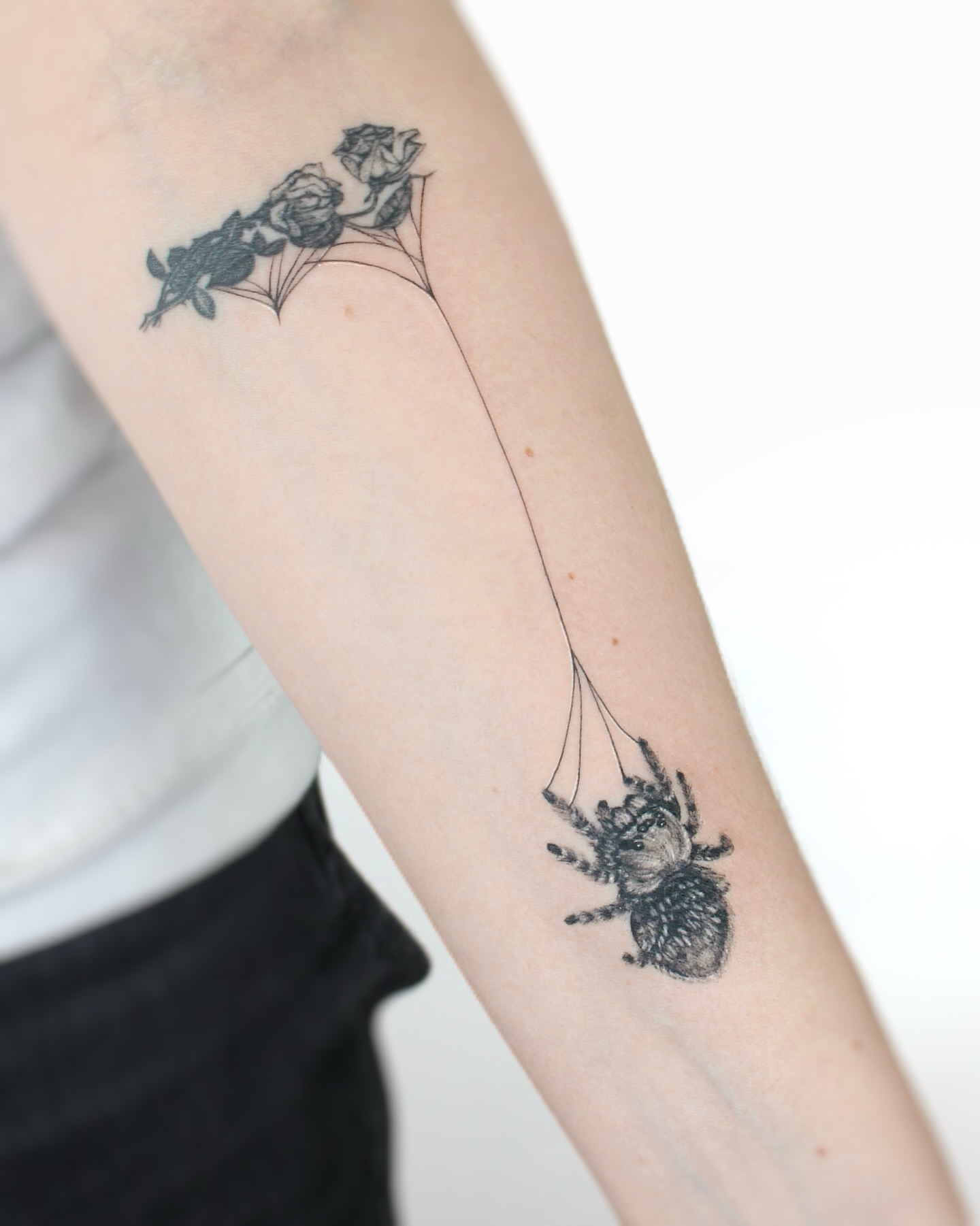 Spider and roses realism tattoo on the forearm by Tatmostat