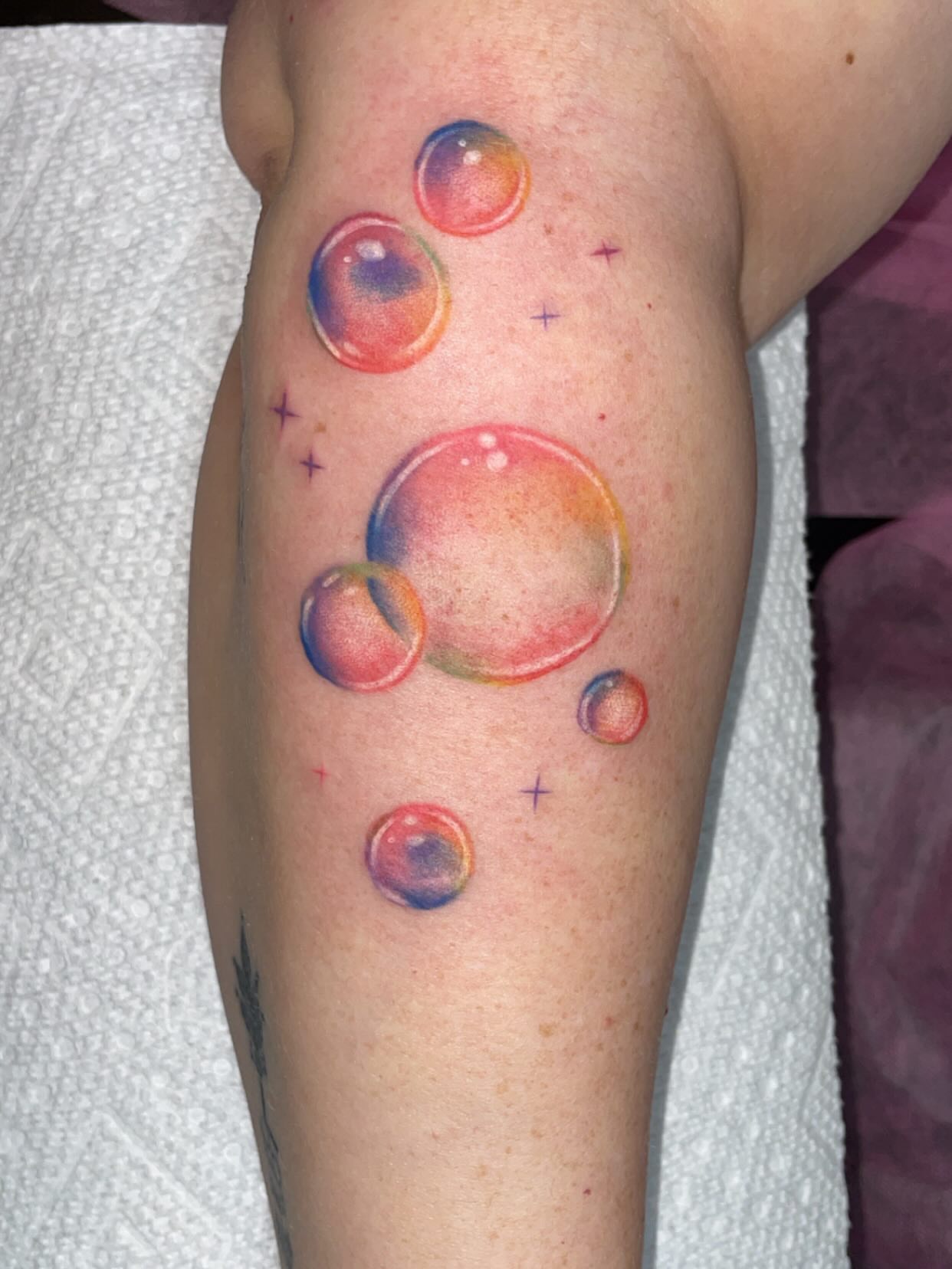 Soap bubbles watercolor tattoo on the forearm by Natalie