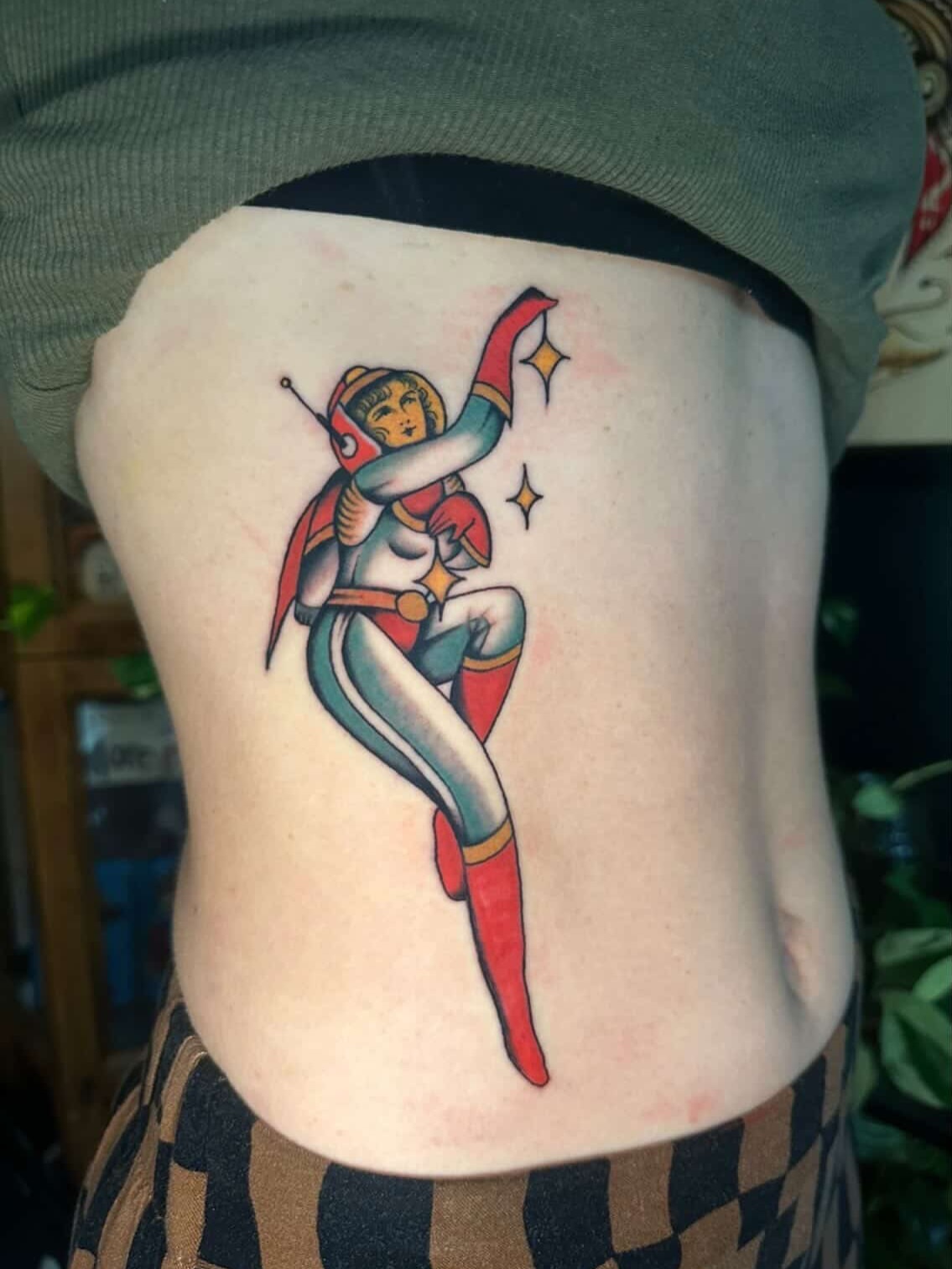 Superheroine American traditional tattoo on the ribs by Max Peterson