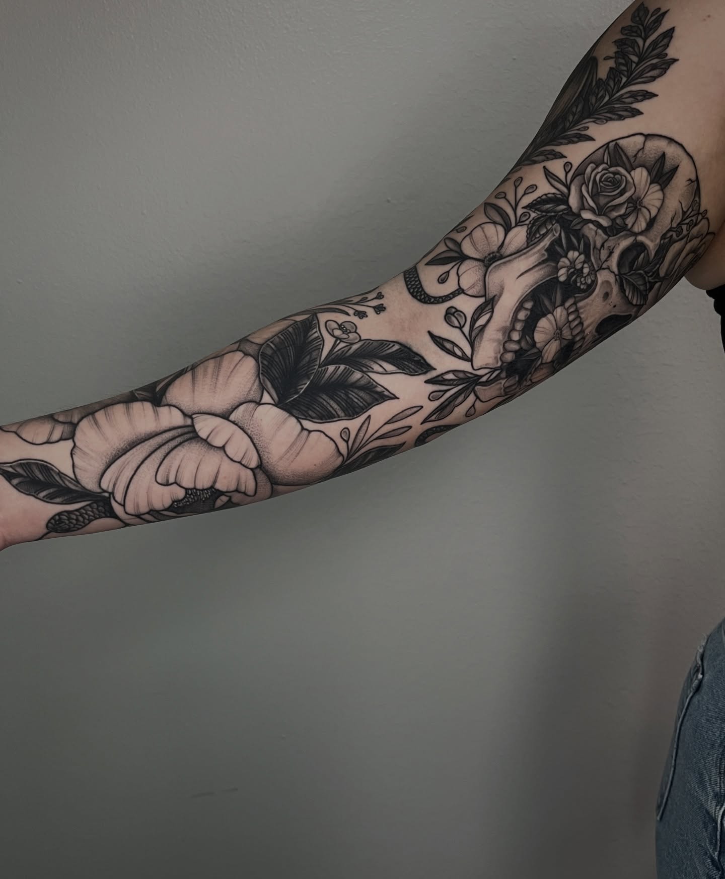 Floral skull black and grey tattoo on the forearm by Jordan Hunt