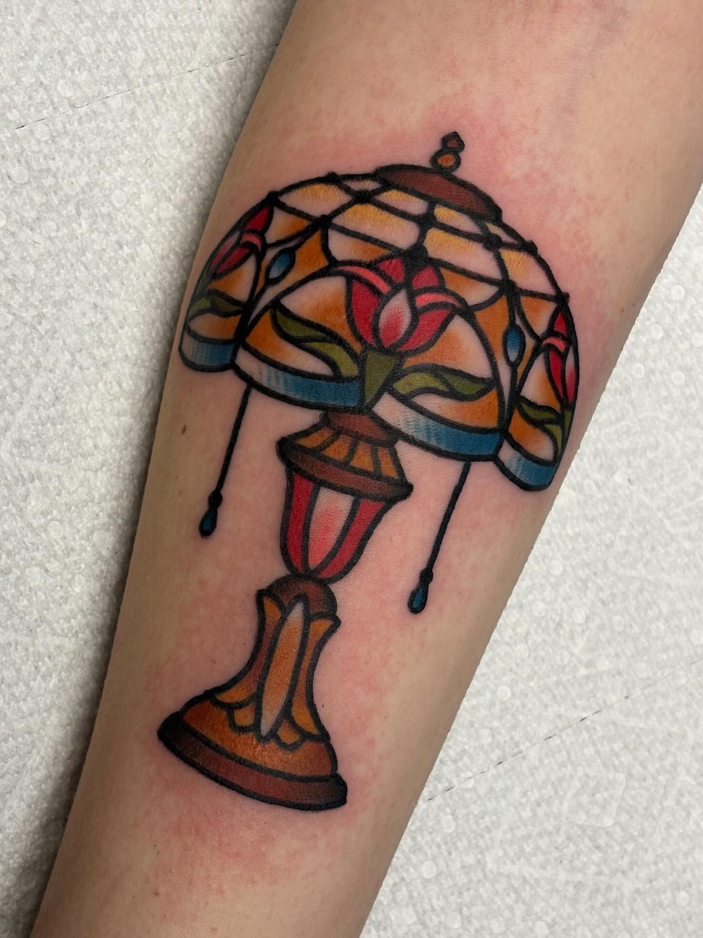Stained glass lamp American traditional tattoo on the forearm by Dakota Amato