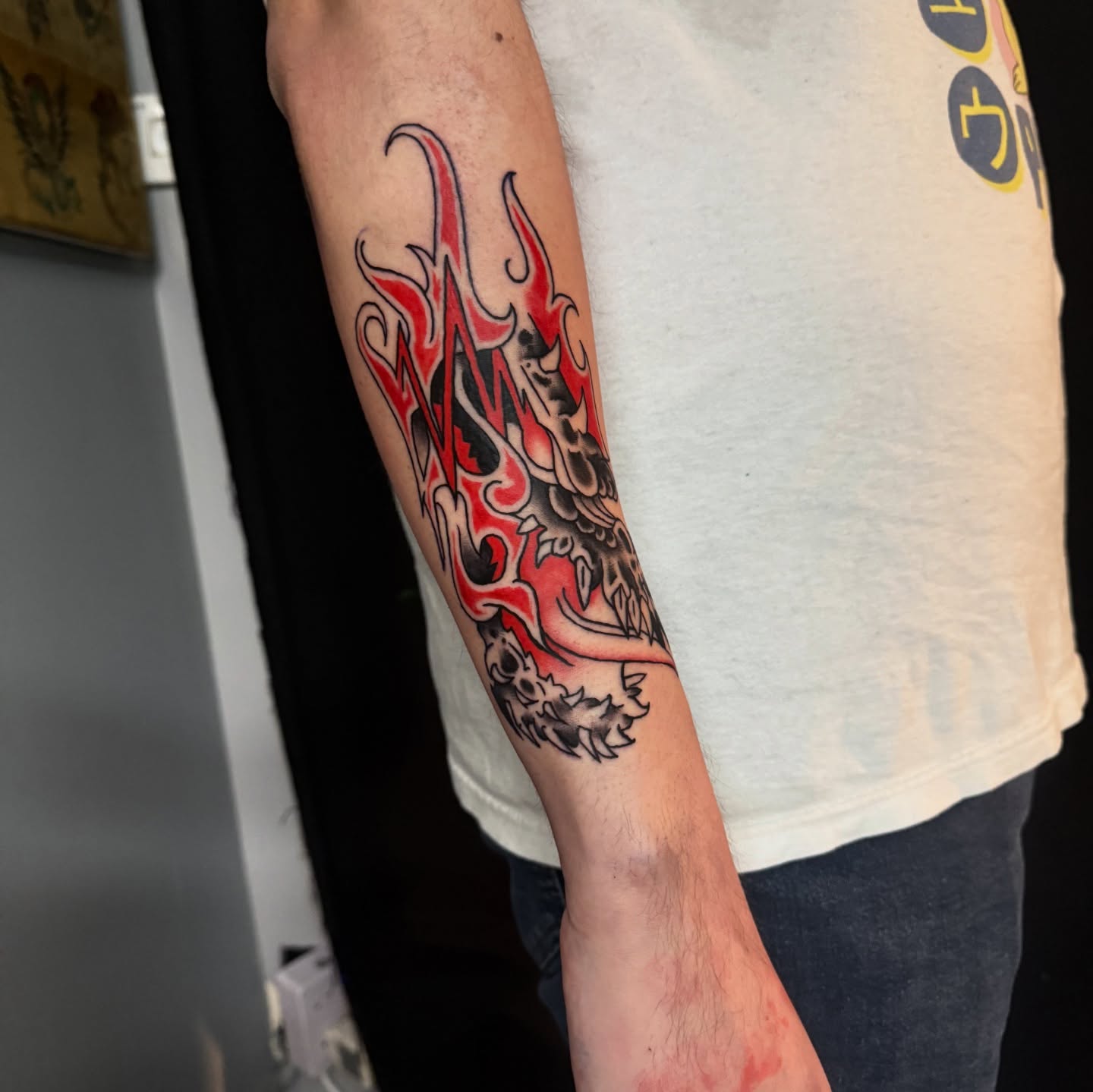 Flame and dragon American traditional tattoo on the forearm by Gabe Rosen