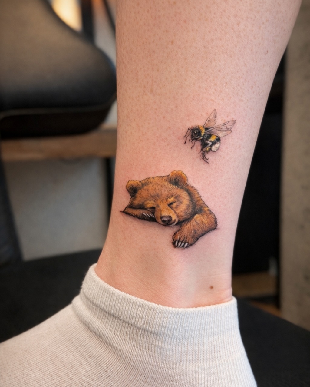 Sleeping bear and bee realism tattoo on the forearm by Aristova Anastasia
