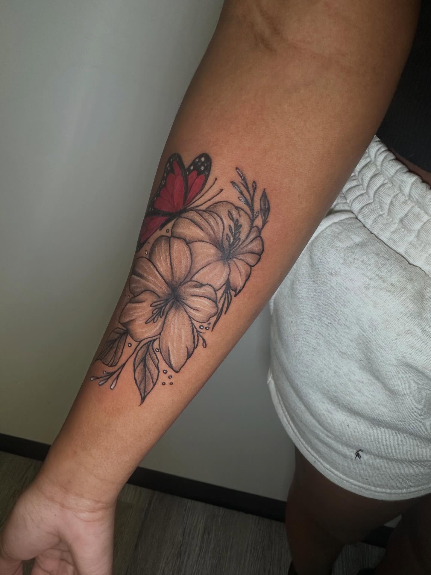 Flower and butterfly black and grey tattoo on the forearm by Javierr Jimenezz