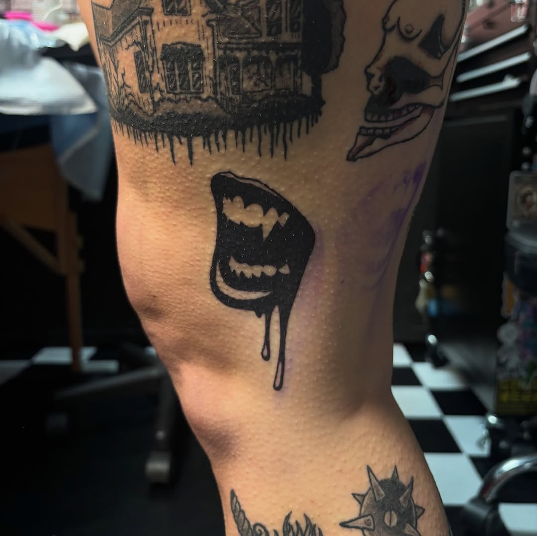 Dripping fangs dark art tattoo on the leg by Rachel