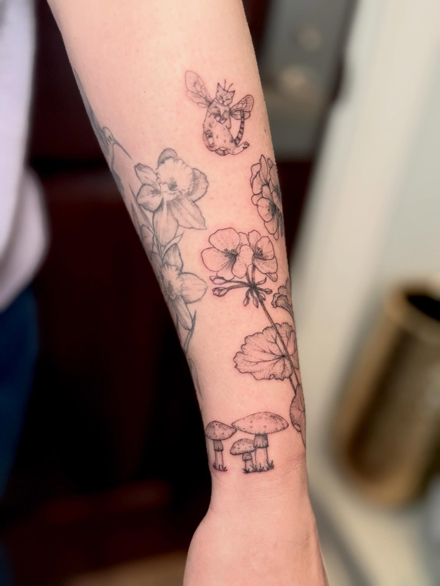Flowers and mushrooms black and grey tattoo on the forearm by Ana Blatt
