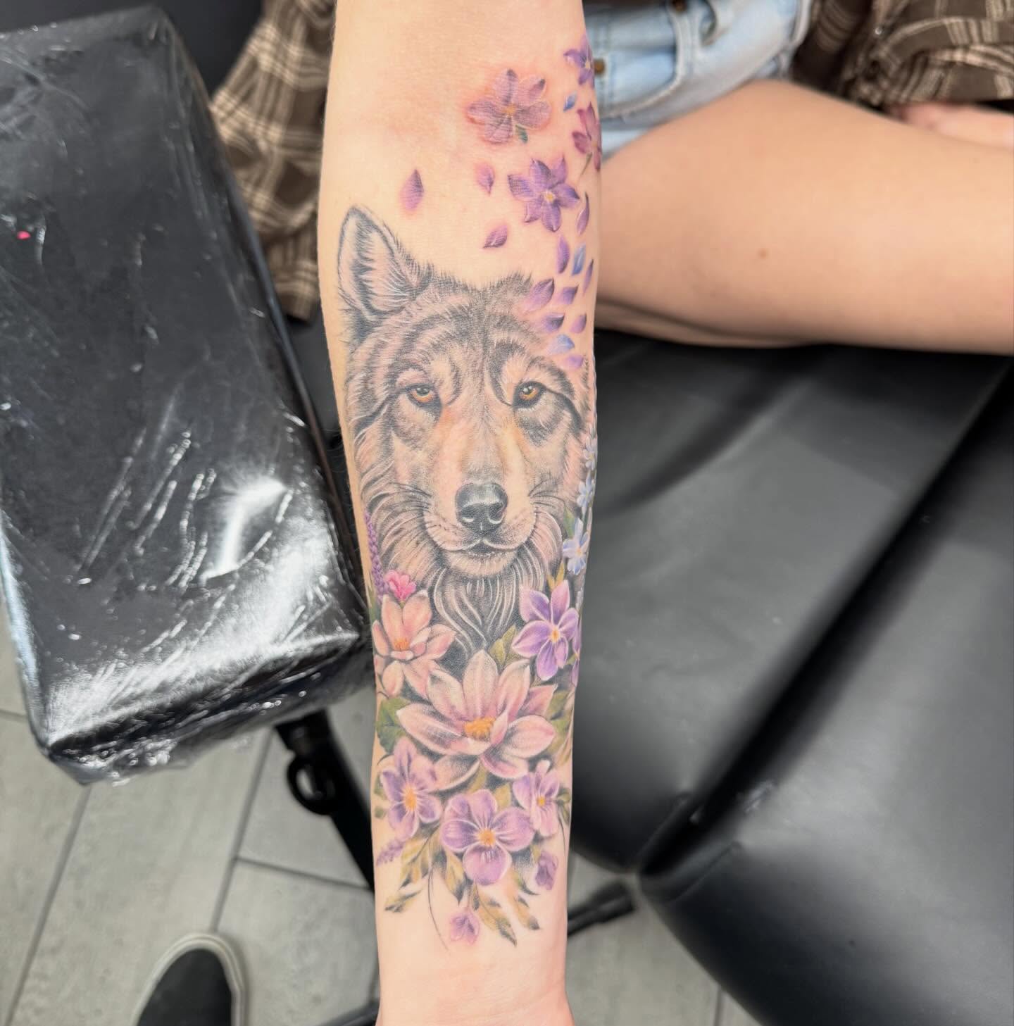 Wolf with flowers realism tattoo on the forearm by Joey Flaherty