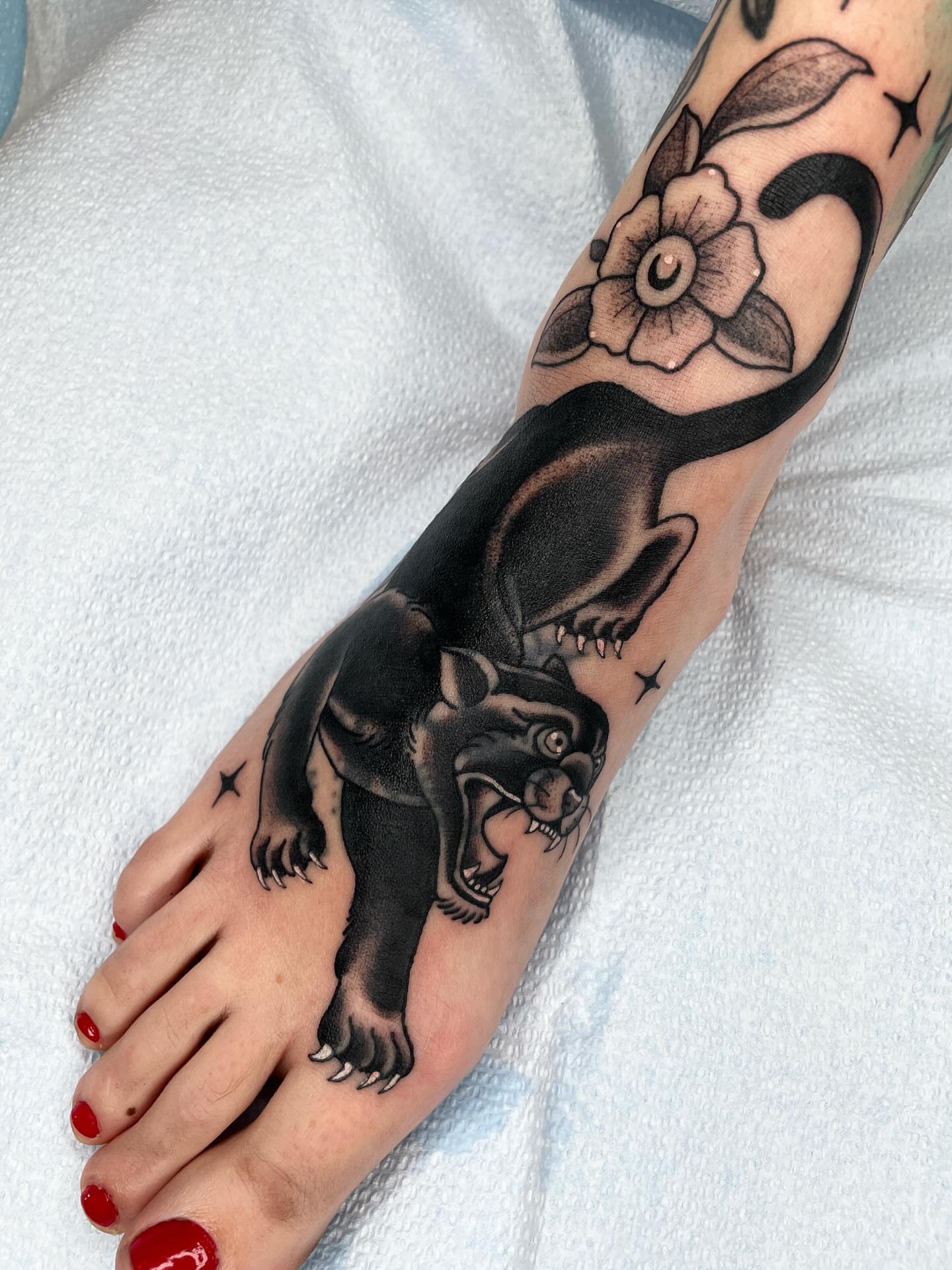 Panther and flower black and grey tattoo on the foot by Emily Lux