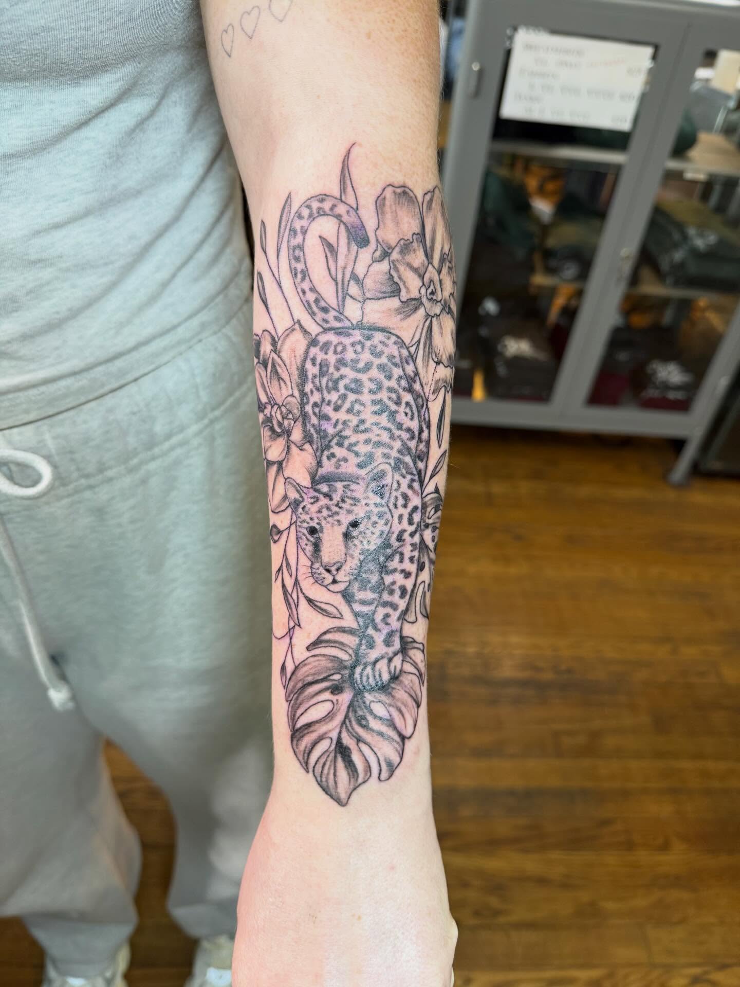 Leopard and flowers realism tattoo on the forearm by Jillian Pardy