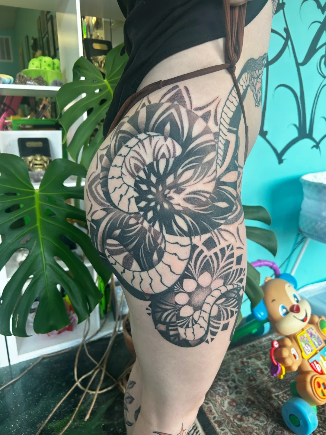 Snake and floral dotwork tattoo on the thigh by Demonic Love Child Tattoos