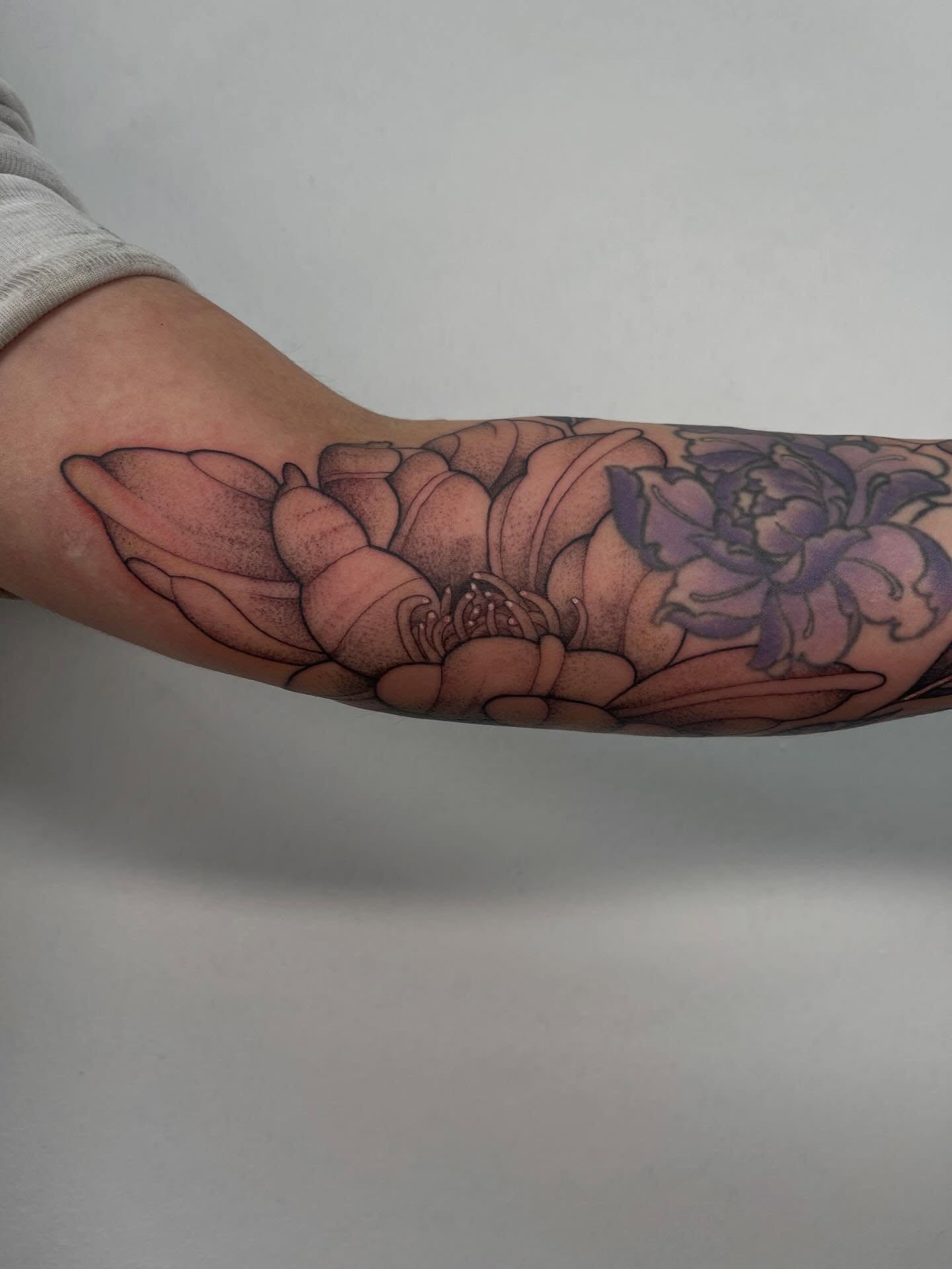 Lotus flowers dotwork tattoo on the forearm by Miesha Busker
