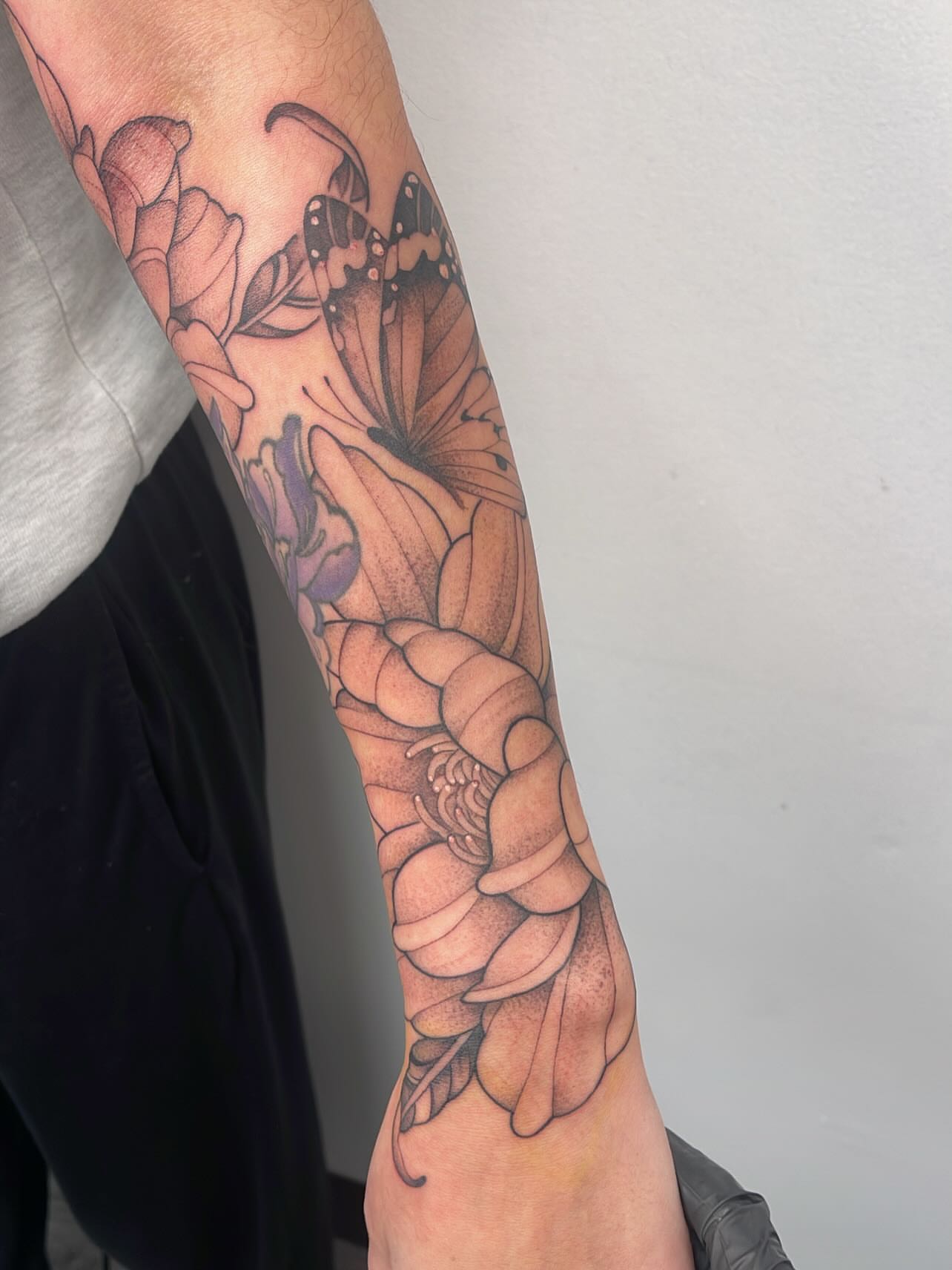 Floral arrangement black and grey tattoo on the forearm by Miesha Busker