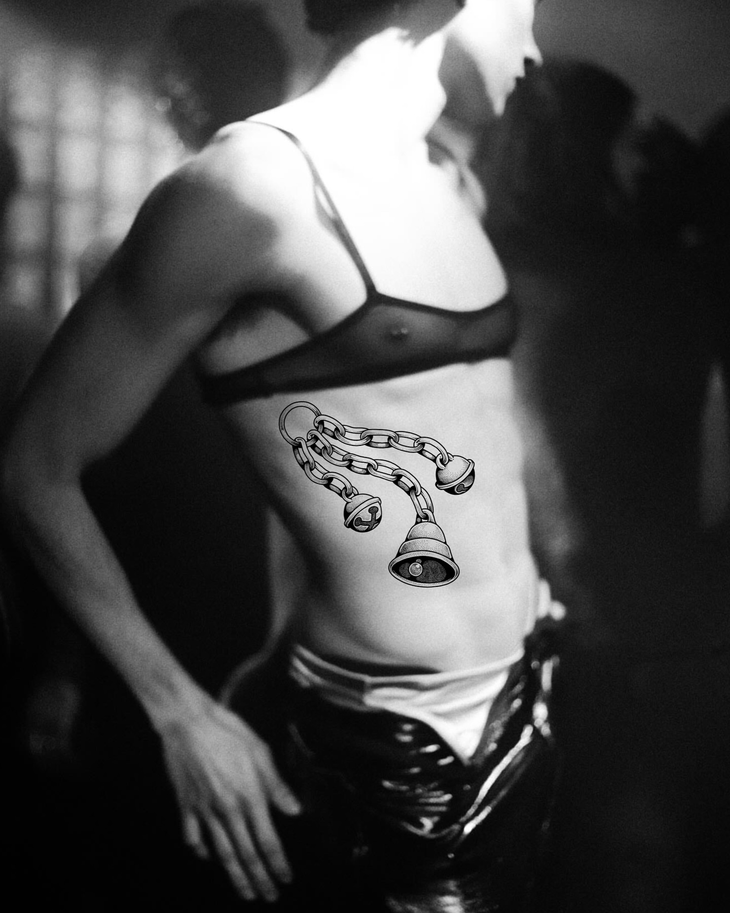 Chains and bells black and grey tattoo on the torso by Lex Lloyd