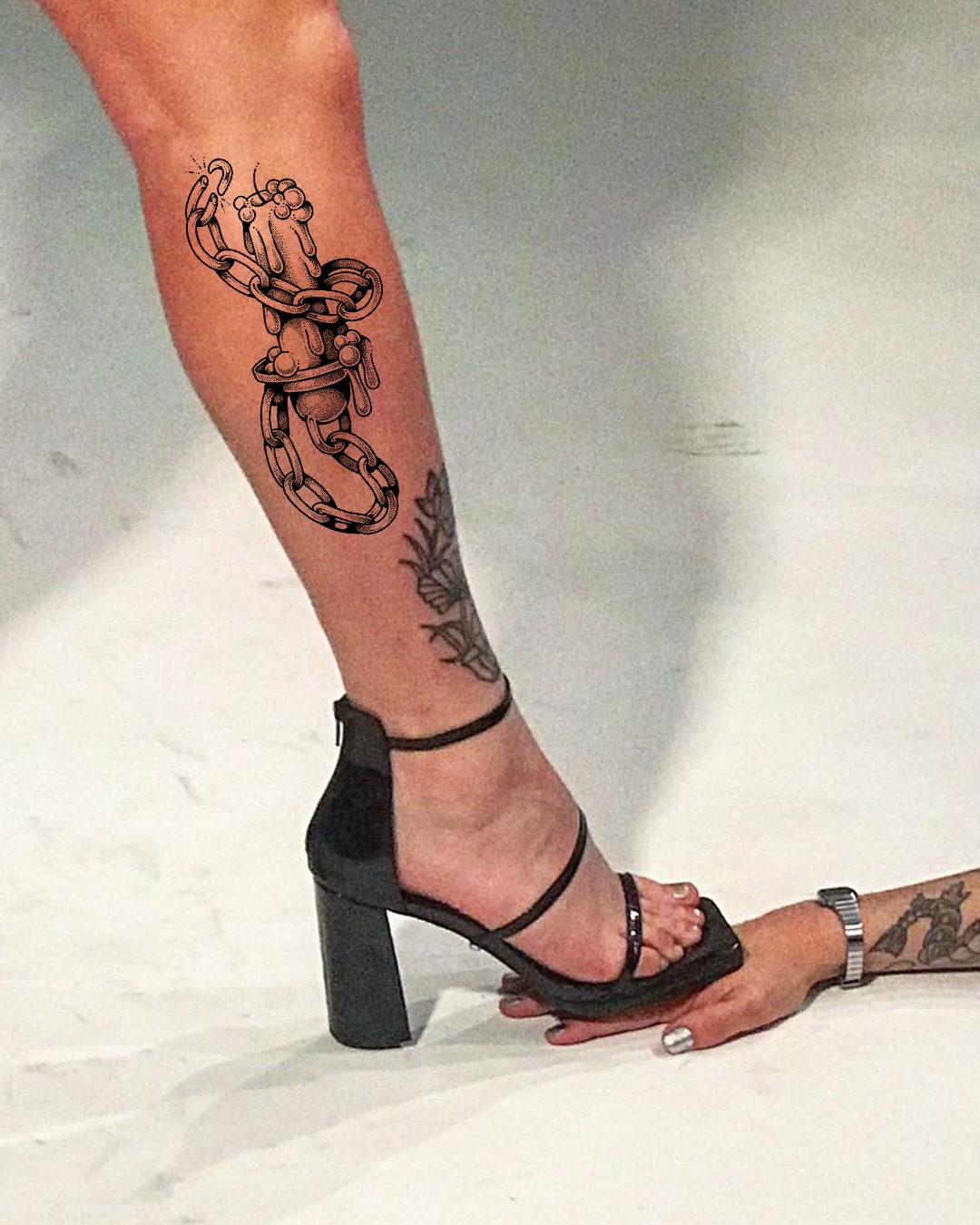 Chains and hands black and grey tattoo on the calf by Lex Lloyd
