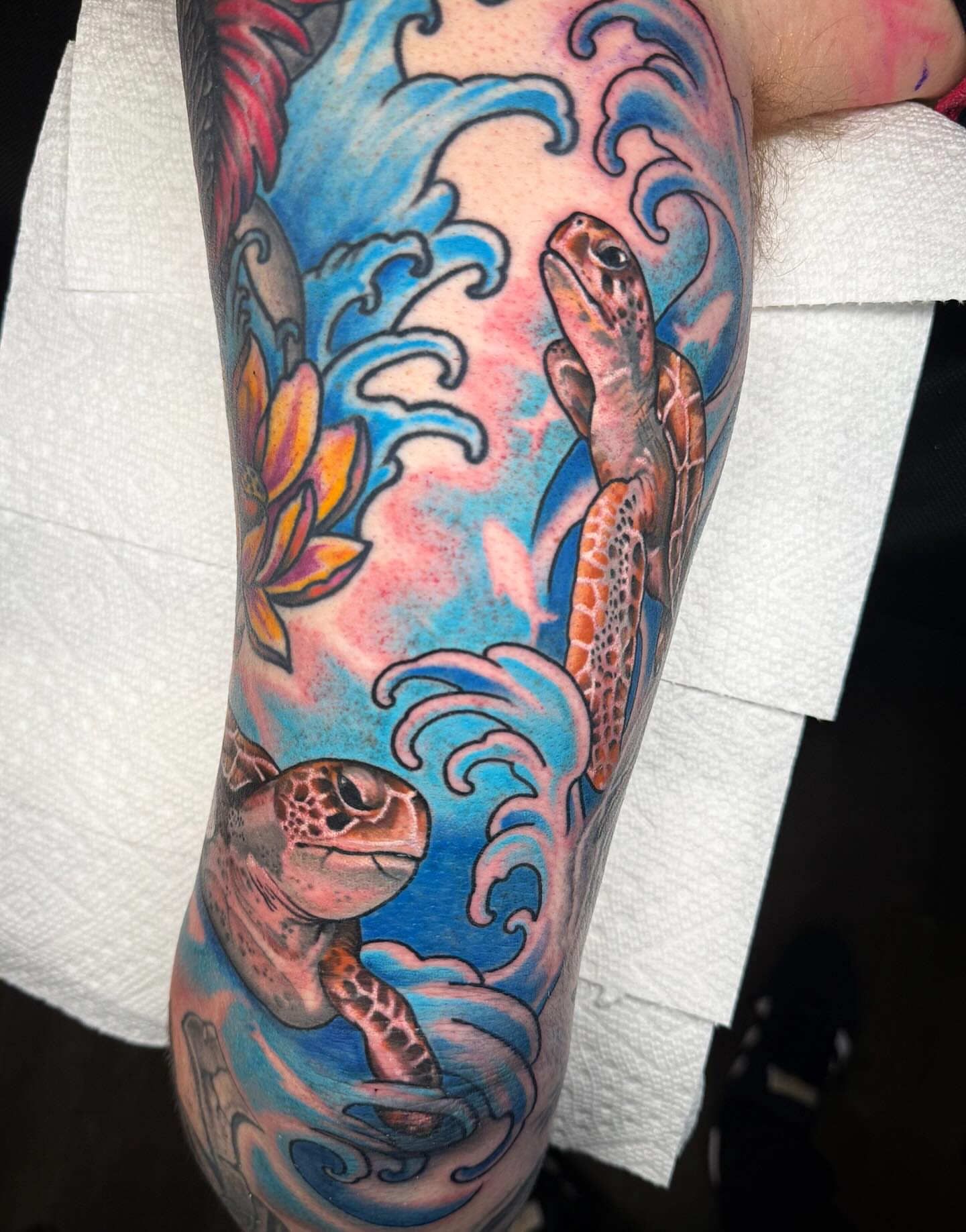 Sea turtle and waves new school tattoo on the forearm by Dani Johnson
