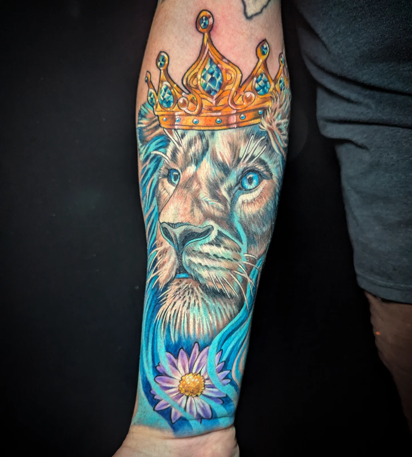 Lion with crown realism tattoo on the forearm by Devon Greig
