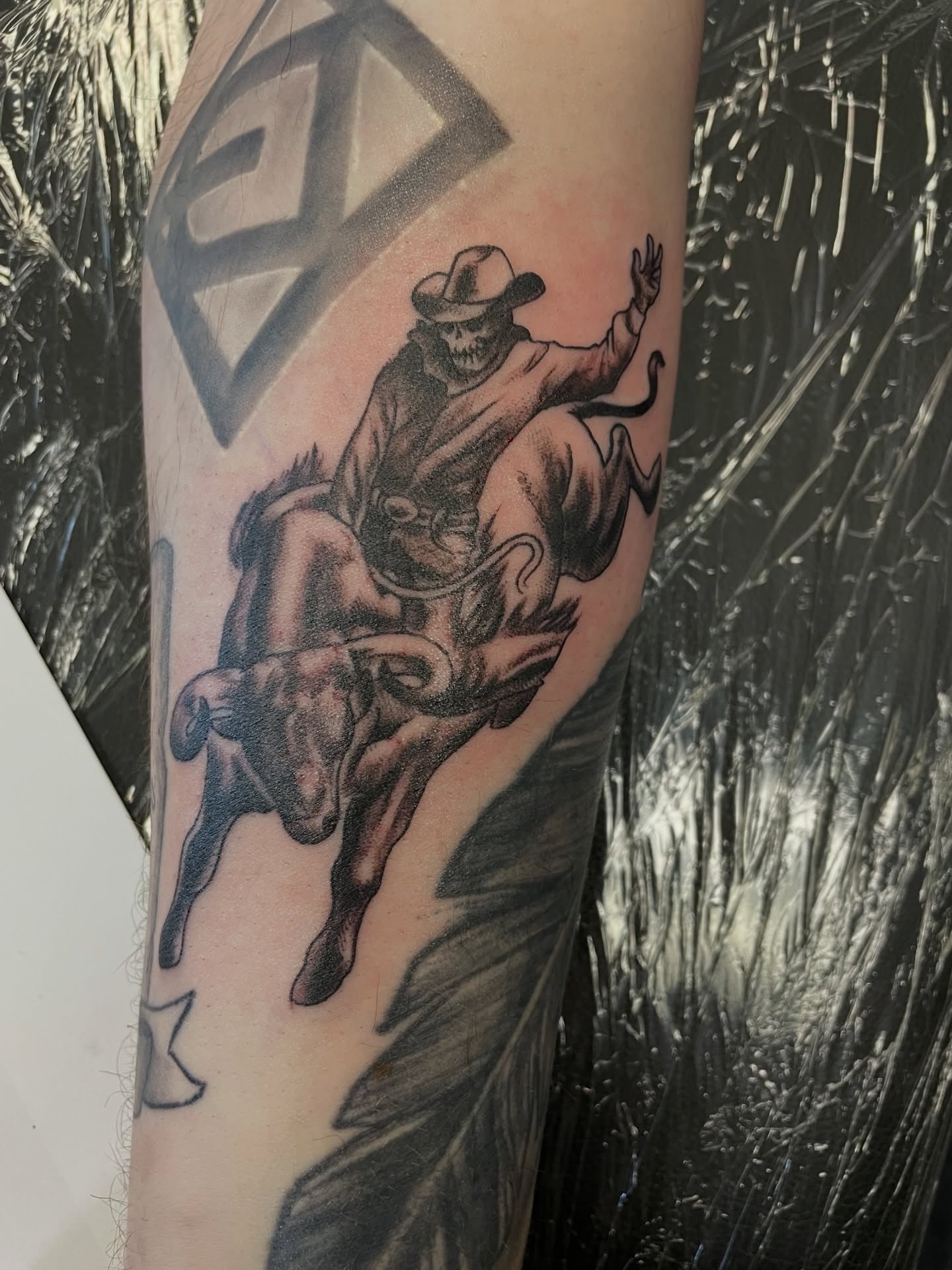 Cowboy riding bull realism tattoo on the forearm by Steven Hodges