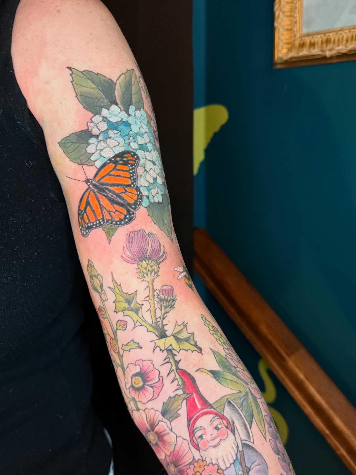 Butterfly and flowers realism tattoo on the forearm by Katy Bisby