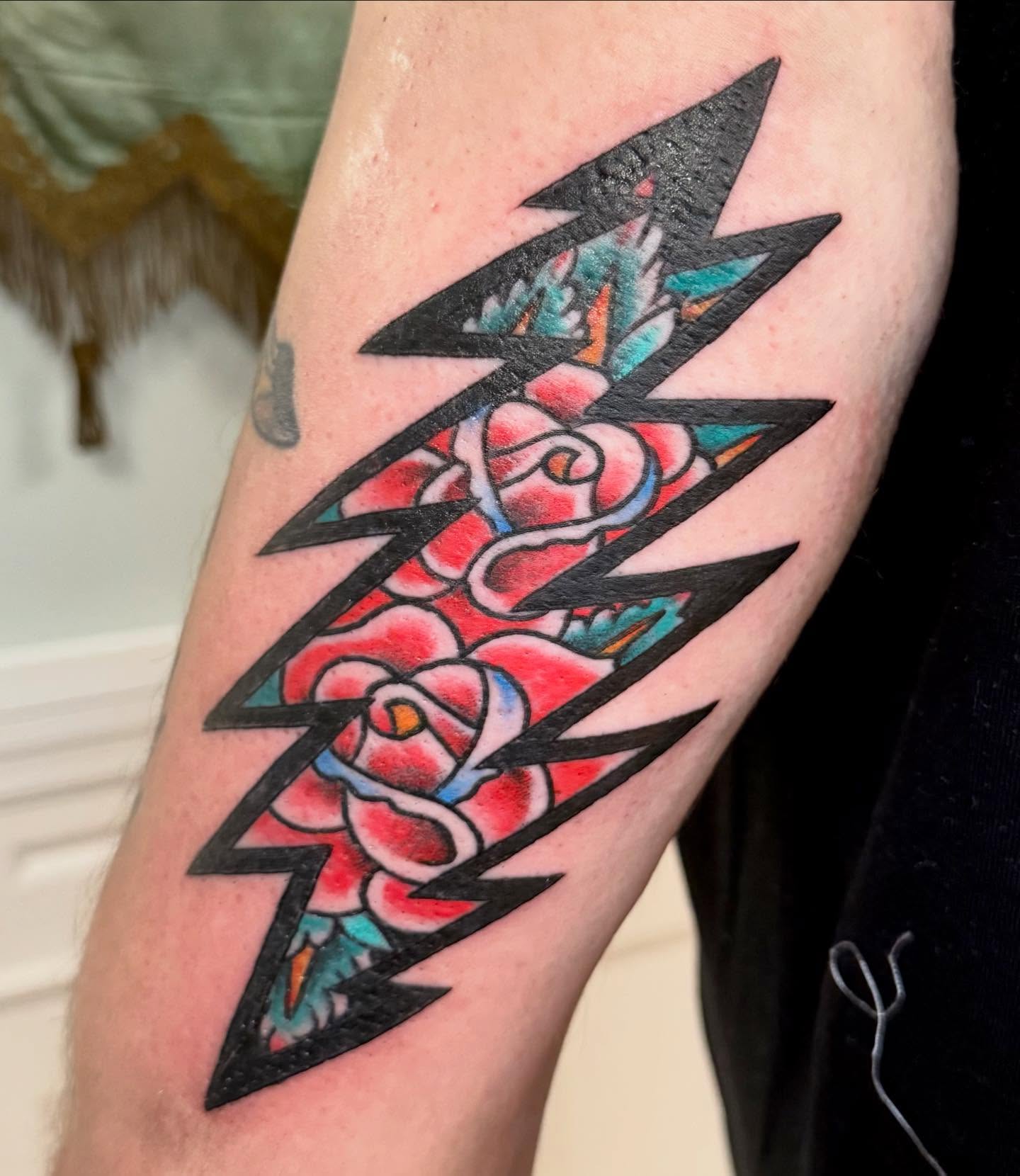 Lightning bolt with roses geometric tattoo on the forearm by Jesse Boss, Nashville, Tennessee