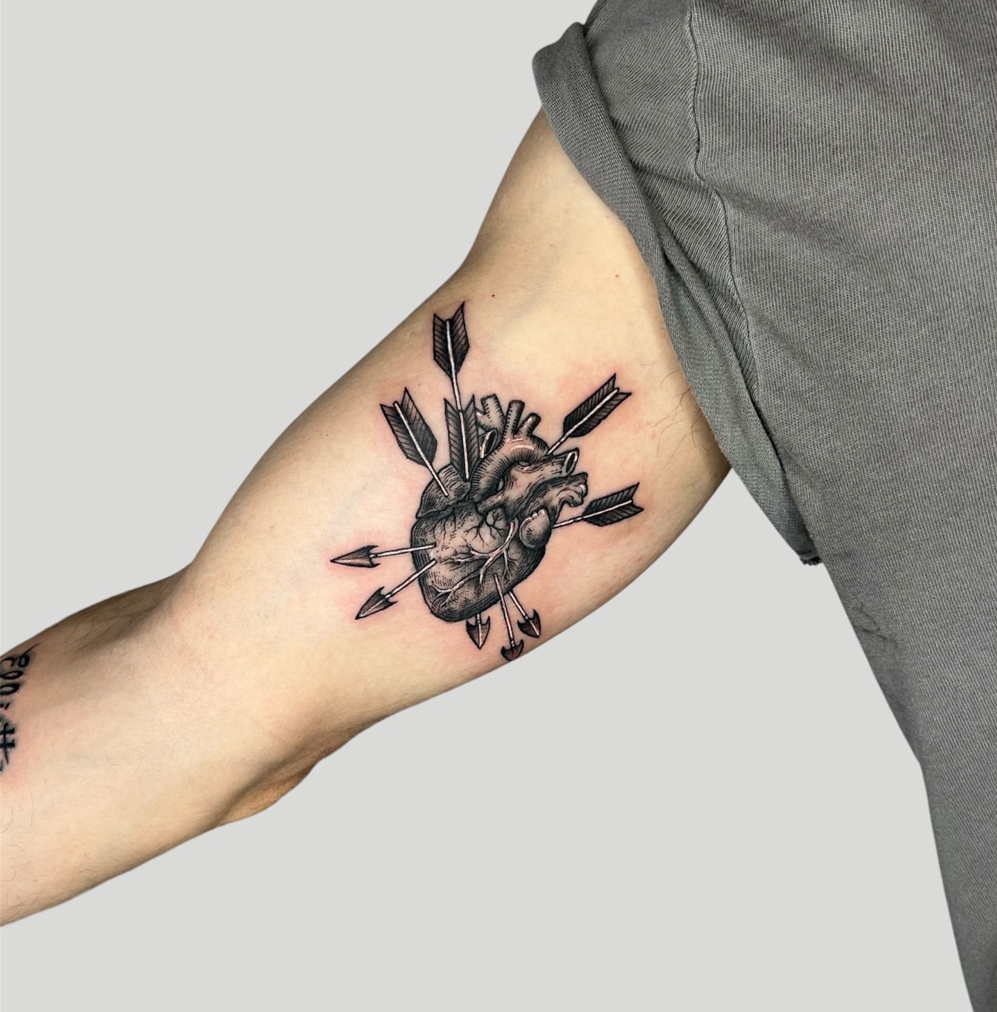 Heart with arrows black and grey tattoo on the forearm by ⚒dptattoos ⚒, East Williamsburg, Brooklyn