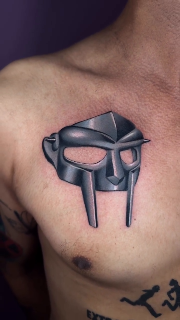 MF DOOM mask realism tattoo on the chest by Mel